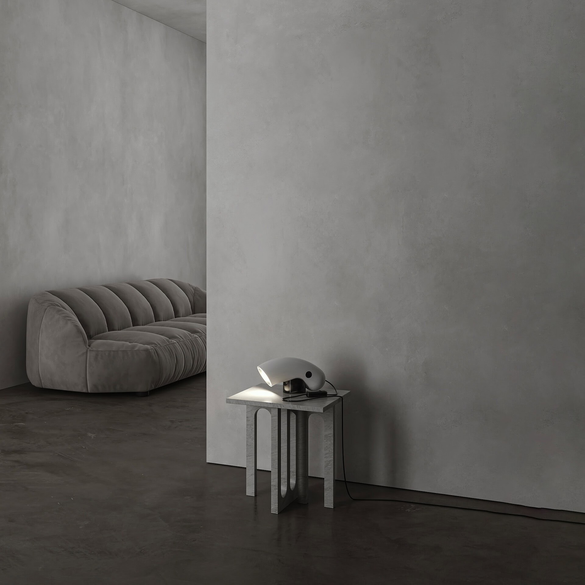 Soft gray velvet sofa in a minimalist modern living space with concrete flooring.