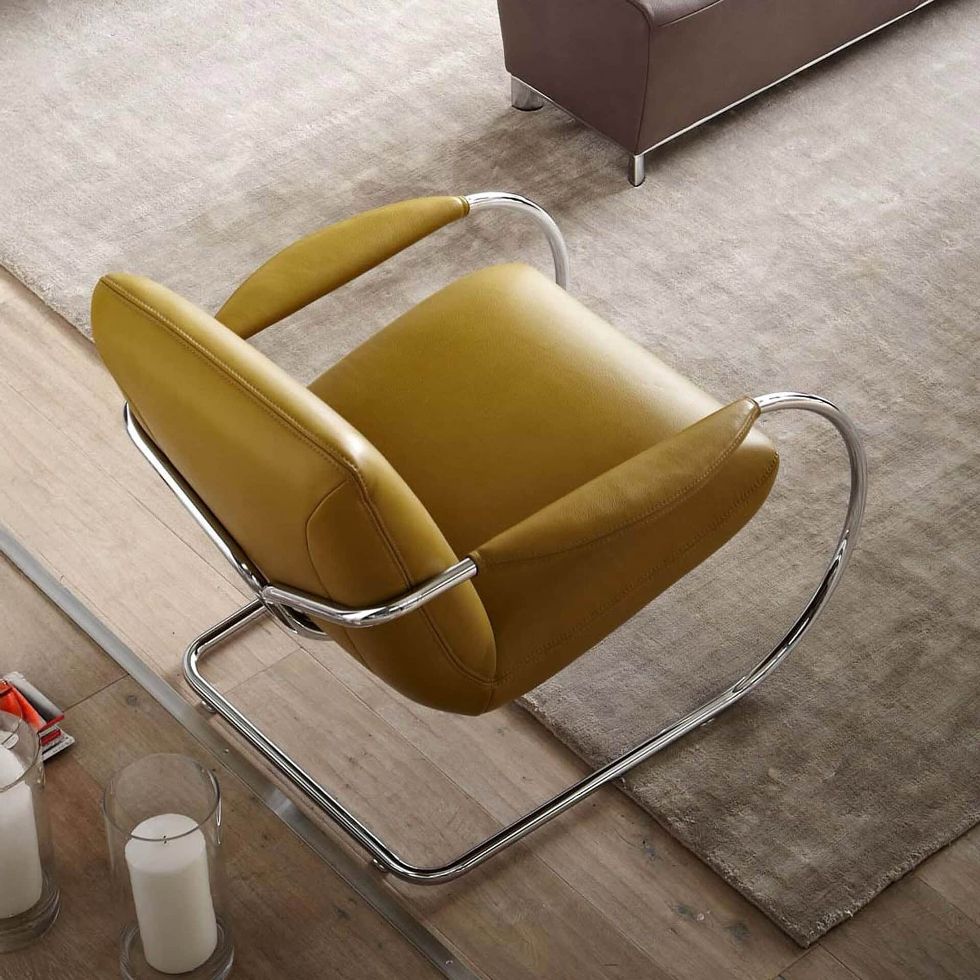 Overhead view of the Jumper Cantilever Armchair in yellow fabric beside a coffee table.