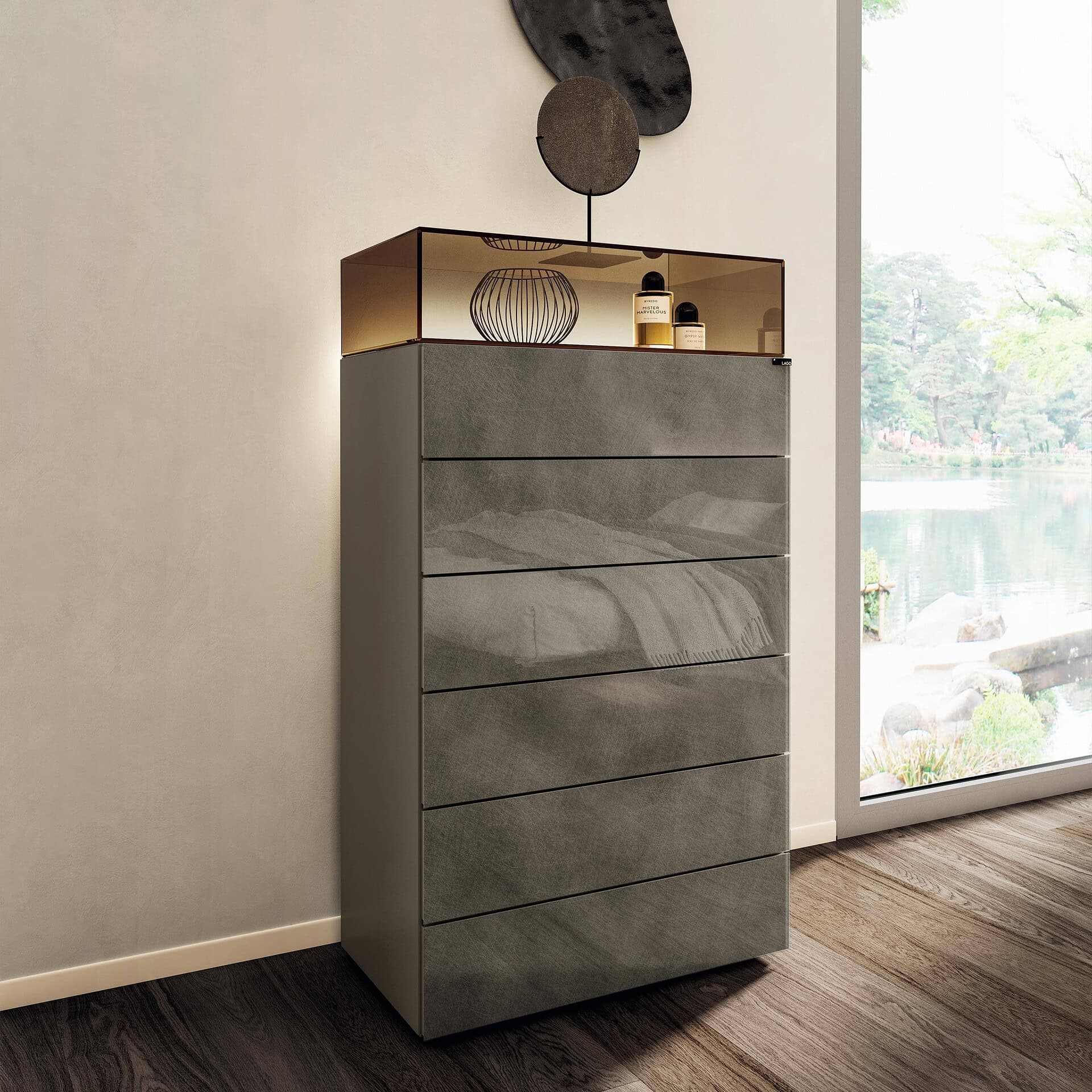 Modern gray glass dresser with gold top and decorative accessories.