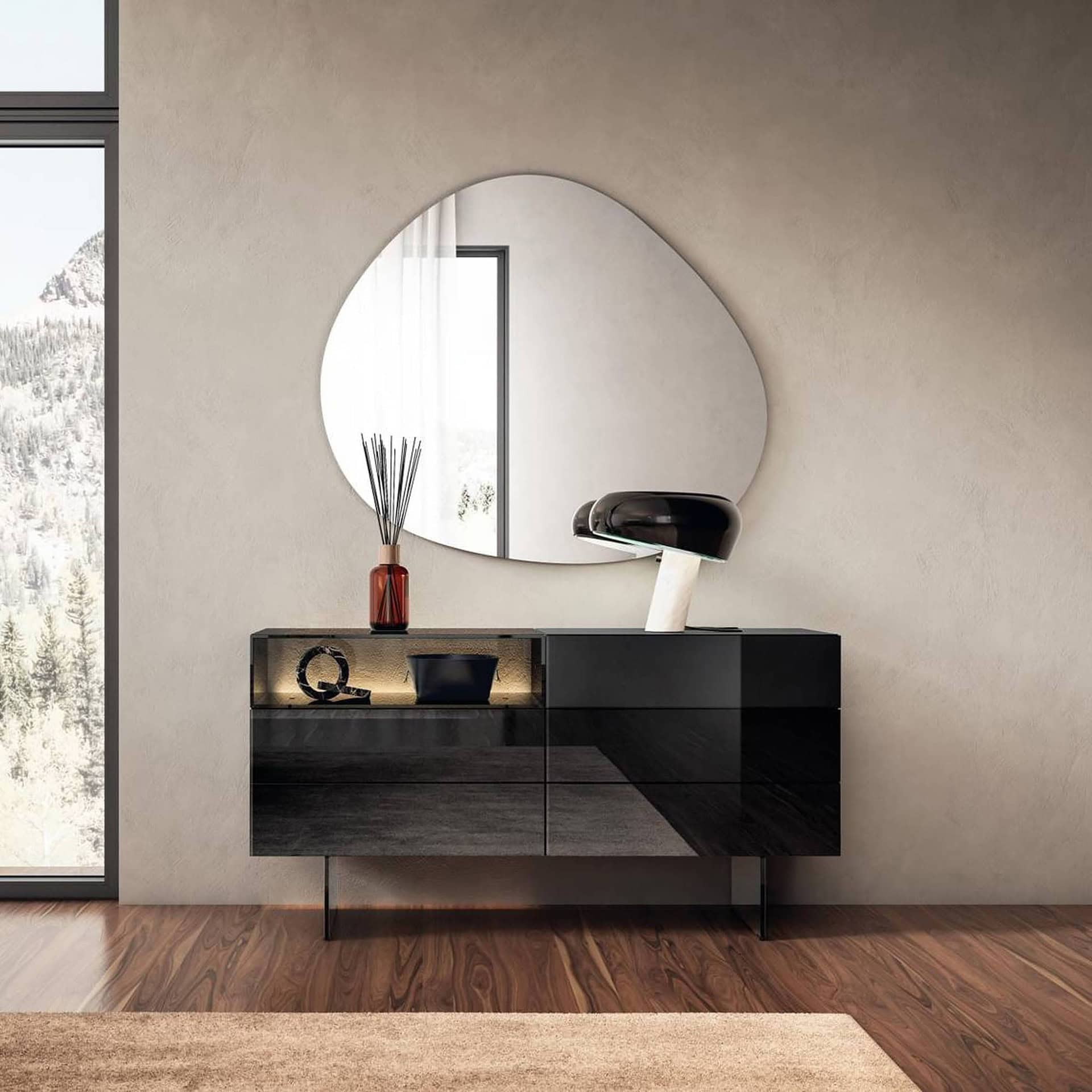 Lago 36e8 Glass Dresser 1904 in smoked glass finish, styled with a modern lamp and decorative accents, placed below an organic-shaped mirror in a contemporary bedroom.