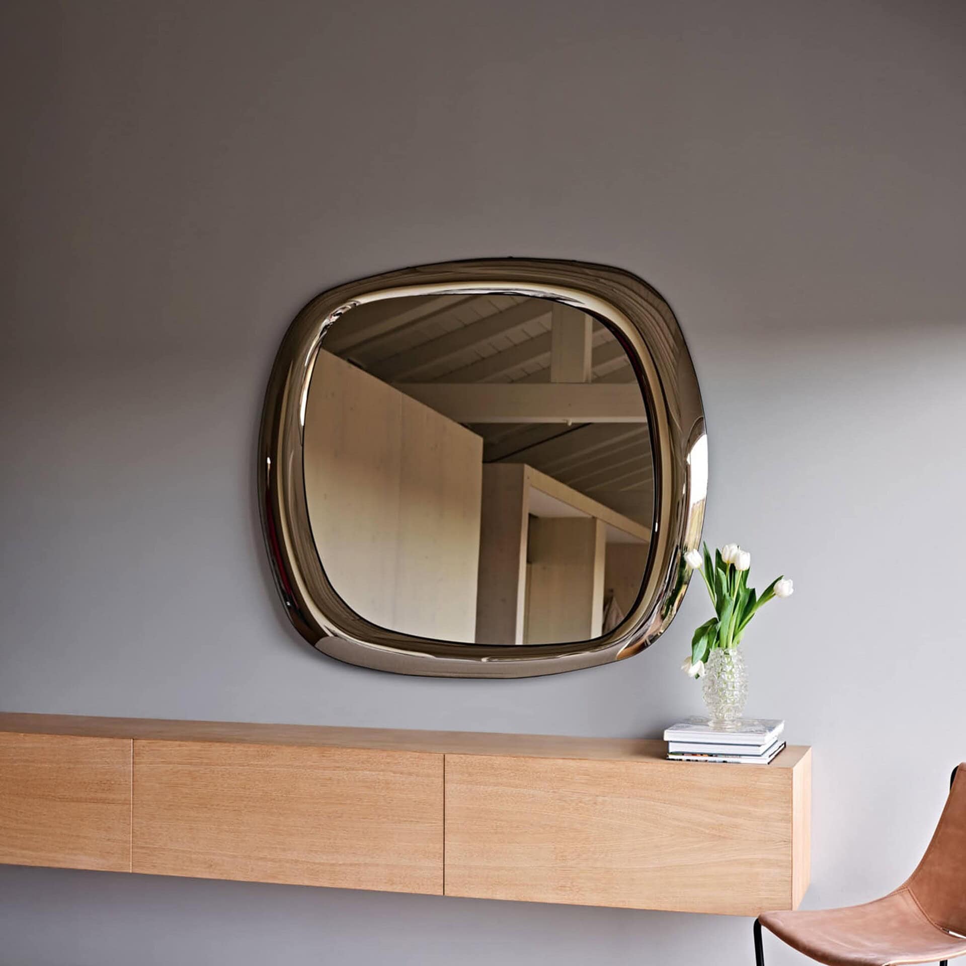 Bold Curved Wall Mirror H120 in a warm-toned interior above a console table.