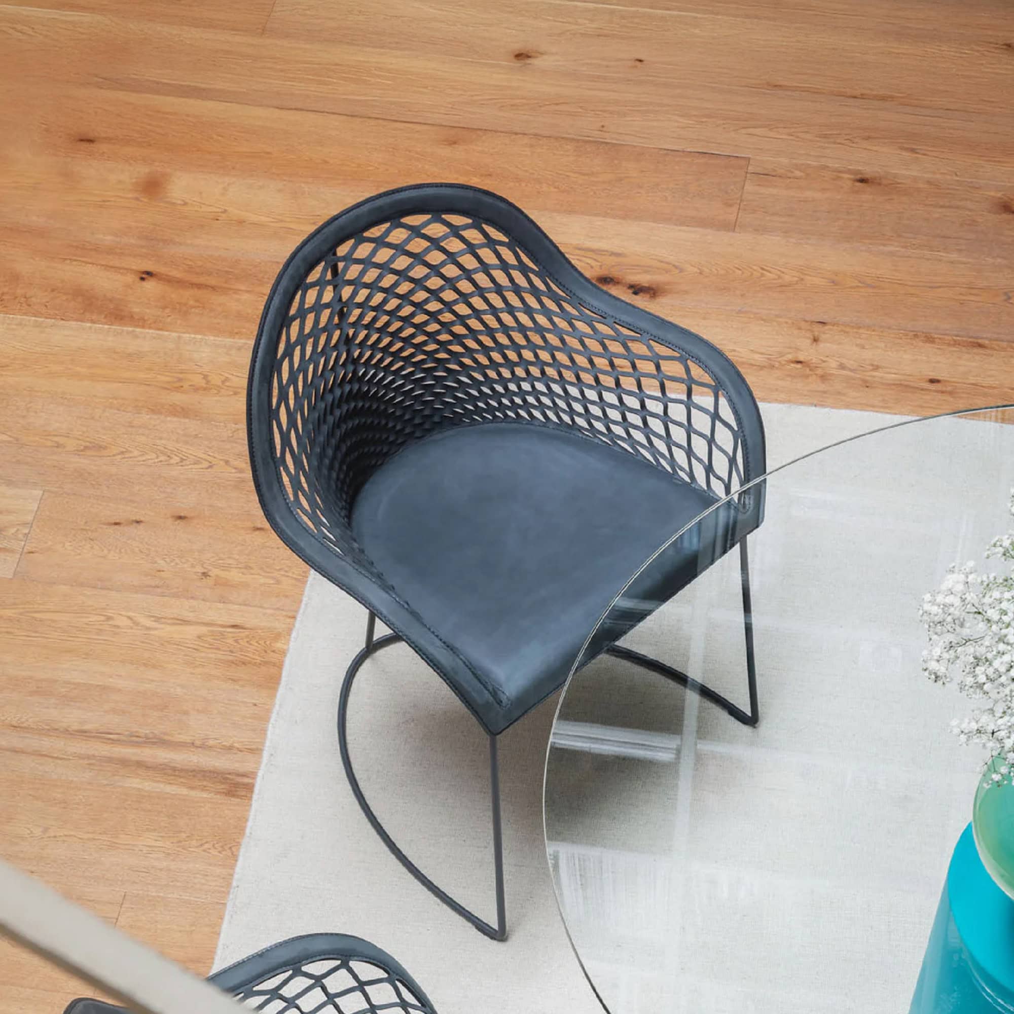Black woven accent chair with metal legs, perfect for contemporary living spaces.