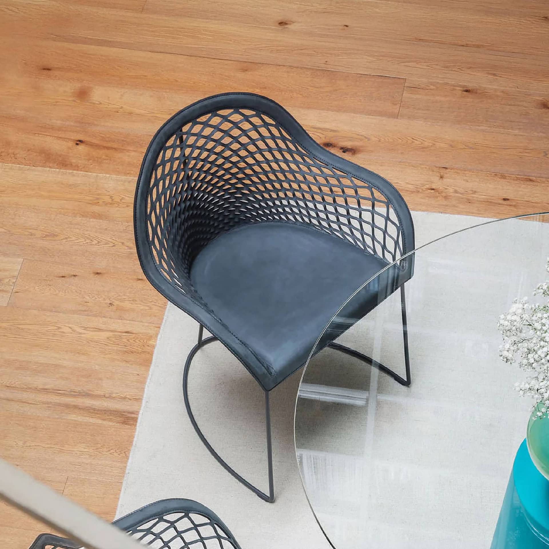 Black woven accent chair with metal legs, perfect for contemporary living spaces.