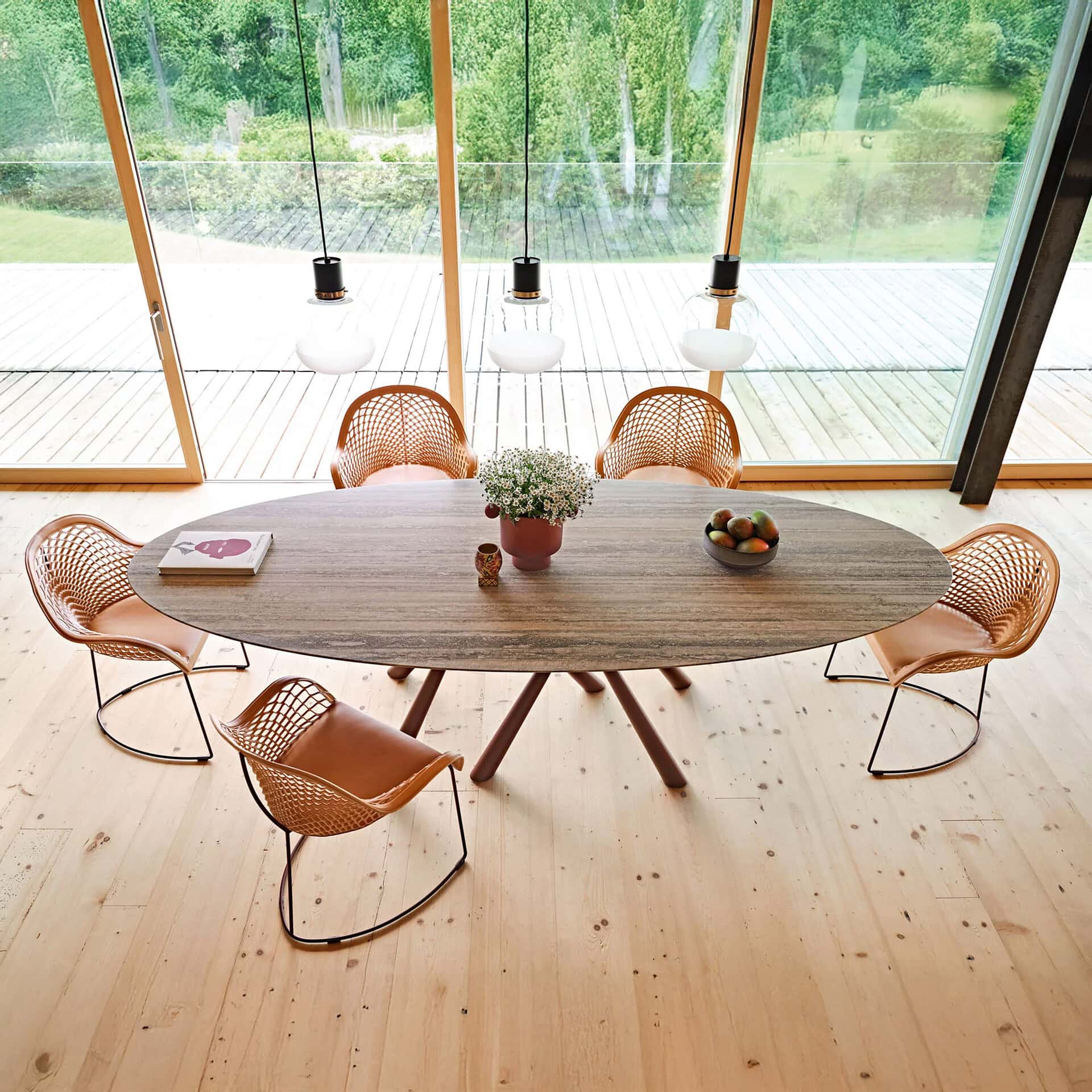 Elegant wooden dining table with rattan chairs in a bright, modern dining space.