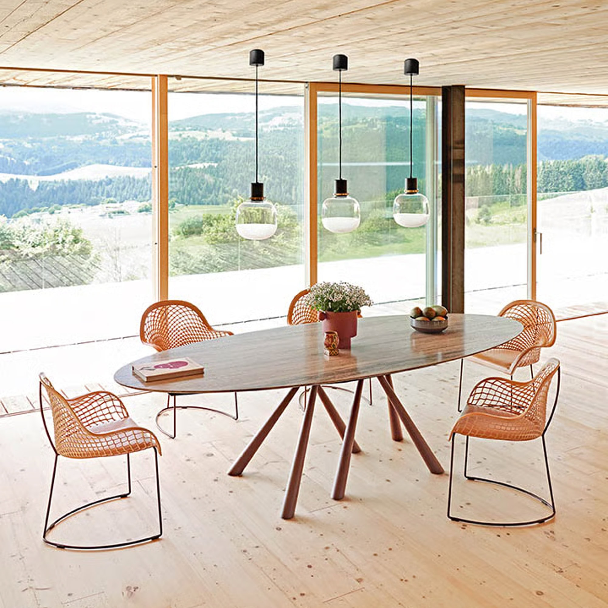 Guapa Leather Armchairs around a dining table in a bright modern interior.
