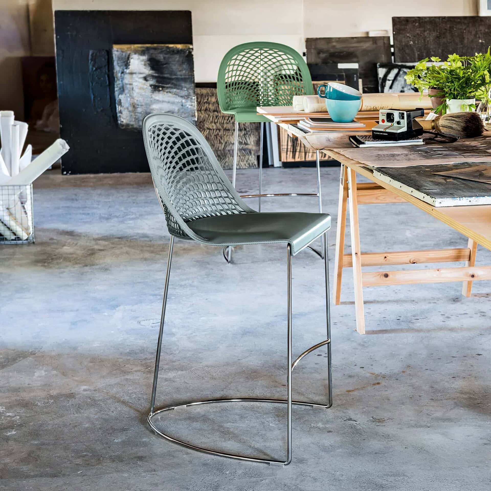 Guapa stools with sled bases and leather seats in a modern dining space with natural light and wood accents.