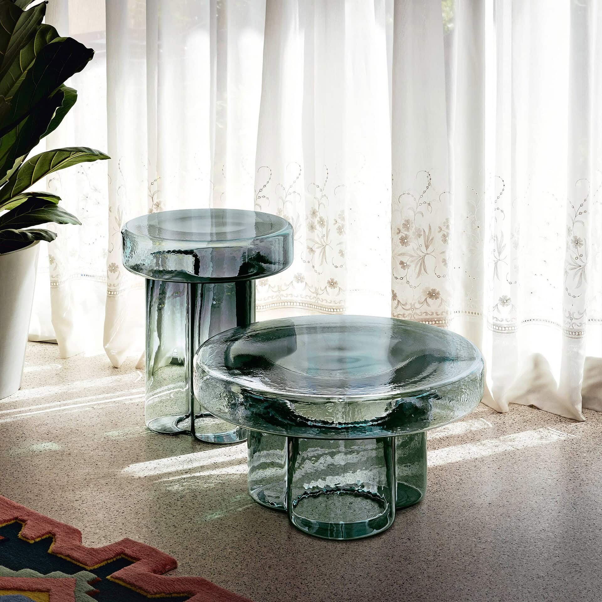 Pair of Soda Hand-Blown Glass Coffee Tables in Petrol Green glass by a window with sheer curtains