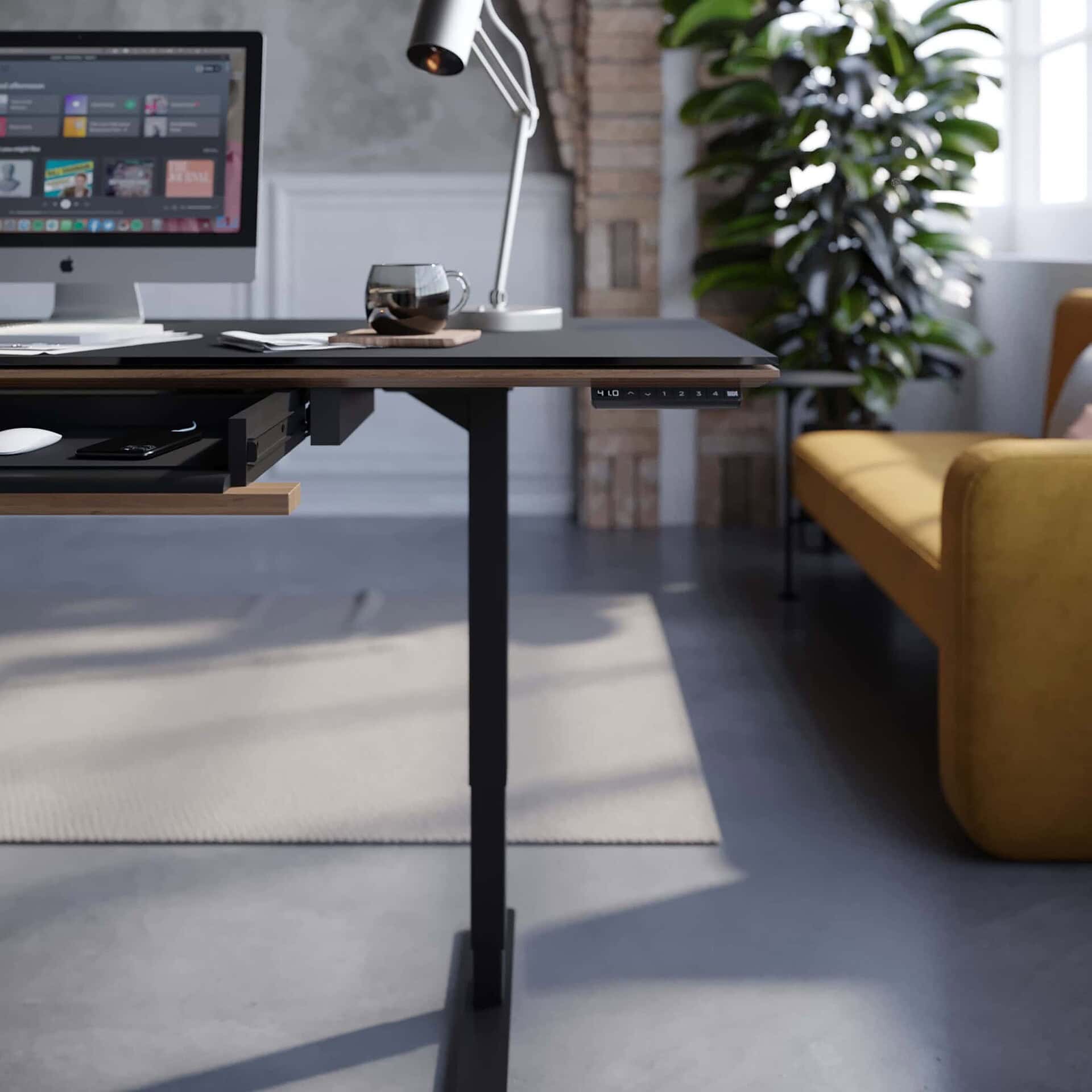 Sequel 20 6152 Sit-Stand Desk with keyboard drawer extended in a contemporary office with plants and sofa nearby.