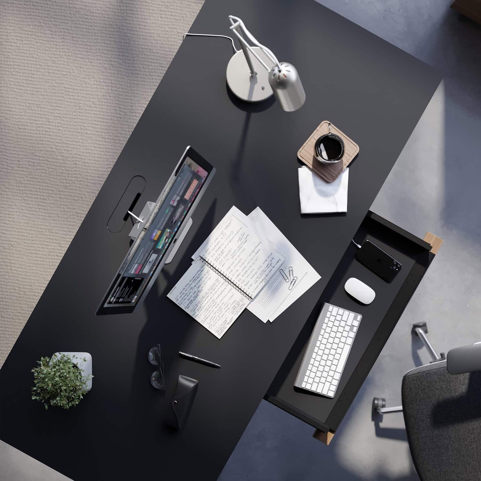 Overhead view of Sequel 20 6152 Sit-Stand Desk showing papers, keyboard, lamp, and work essentials on the black glass surface.