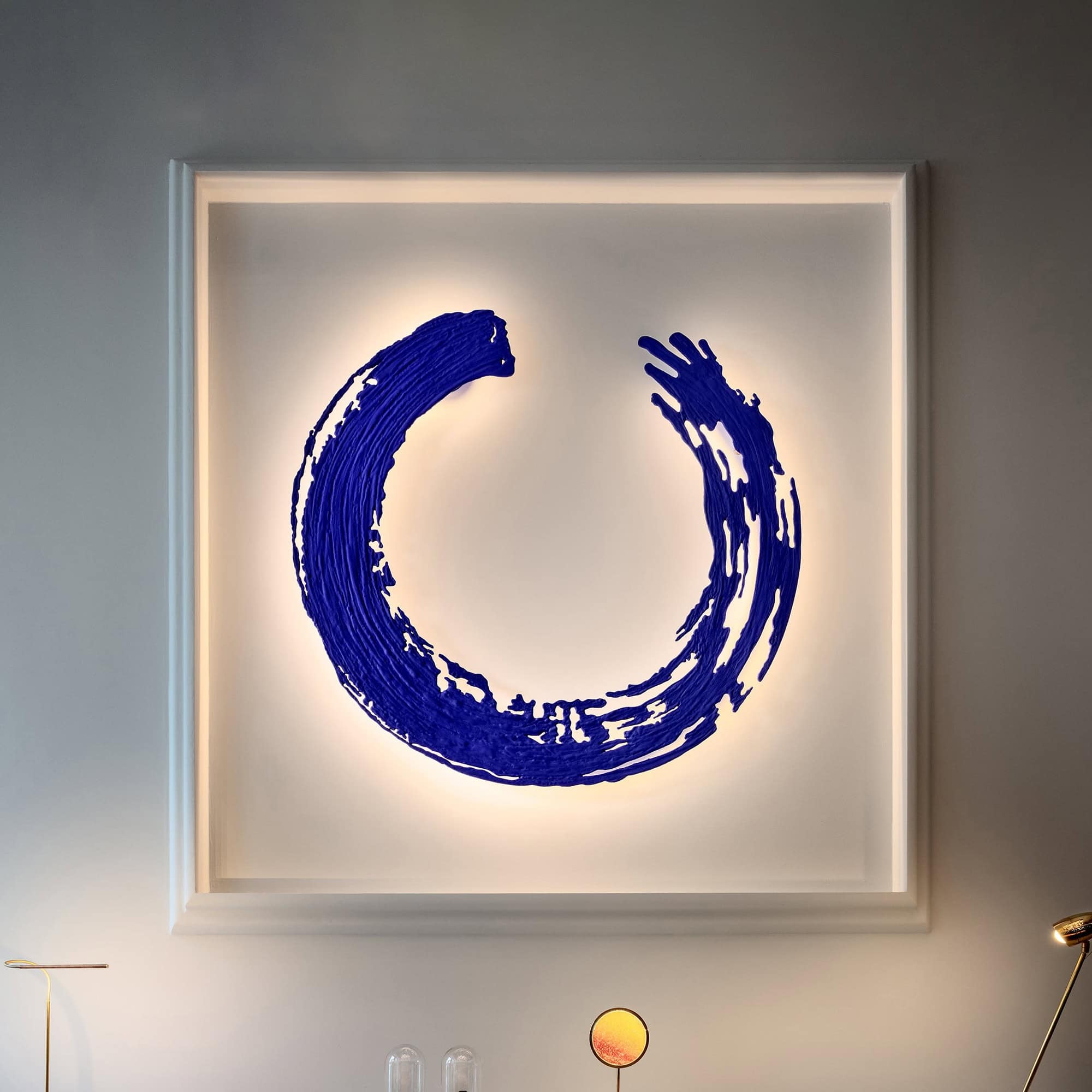 Vibrant blue abstract moon wall art with backlit illumination, modern home decor by Sklar Furnishings.