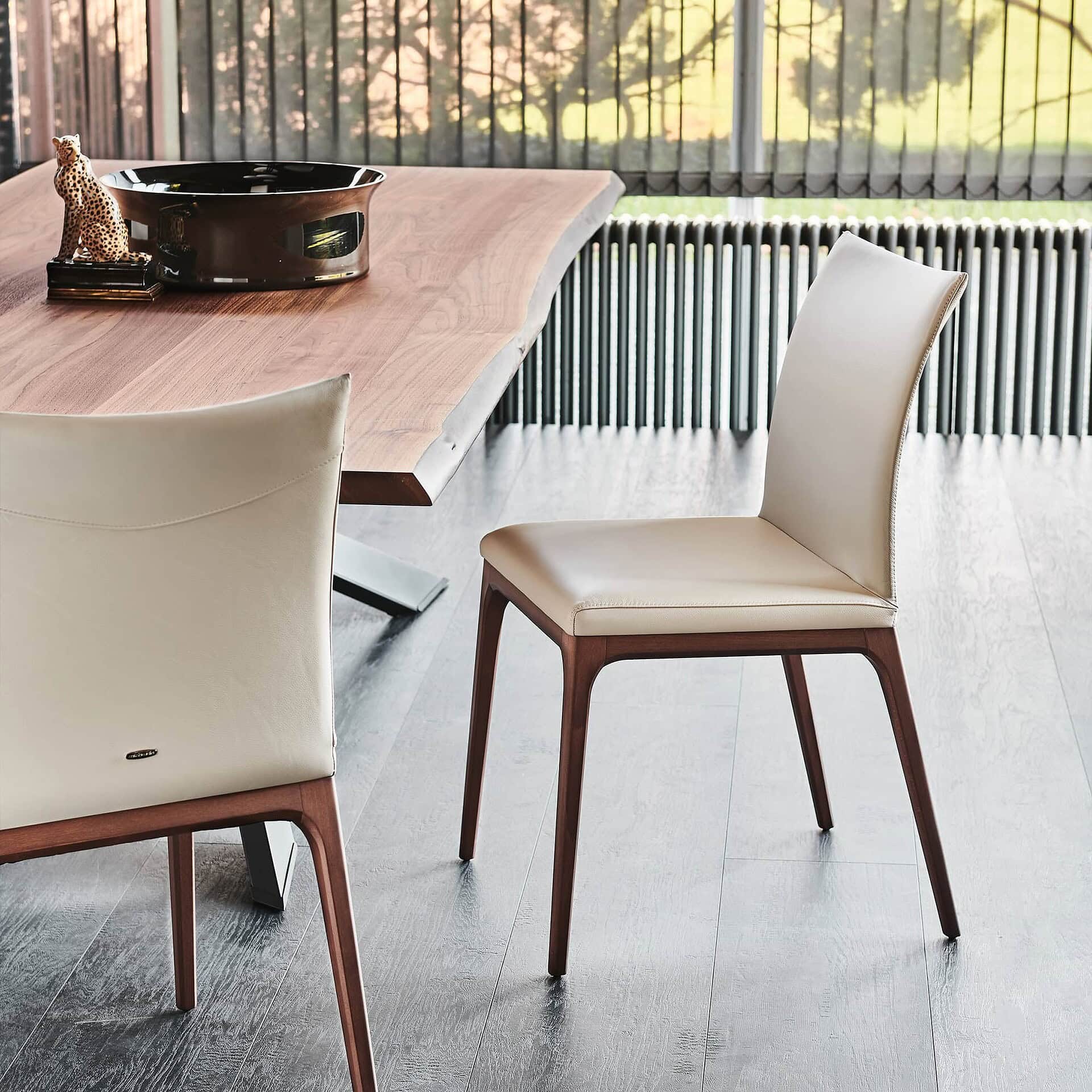 Contemporary dining chair with upholstered seat and wooden legs, perfect for modern interiors.