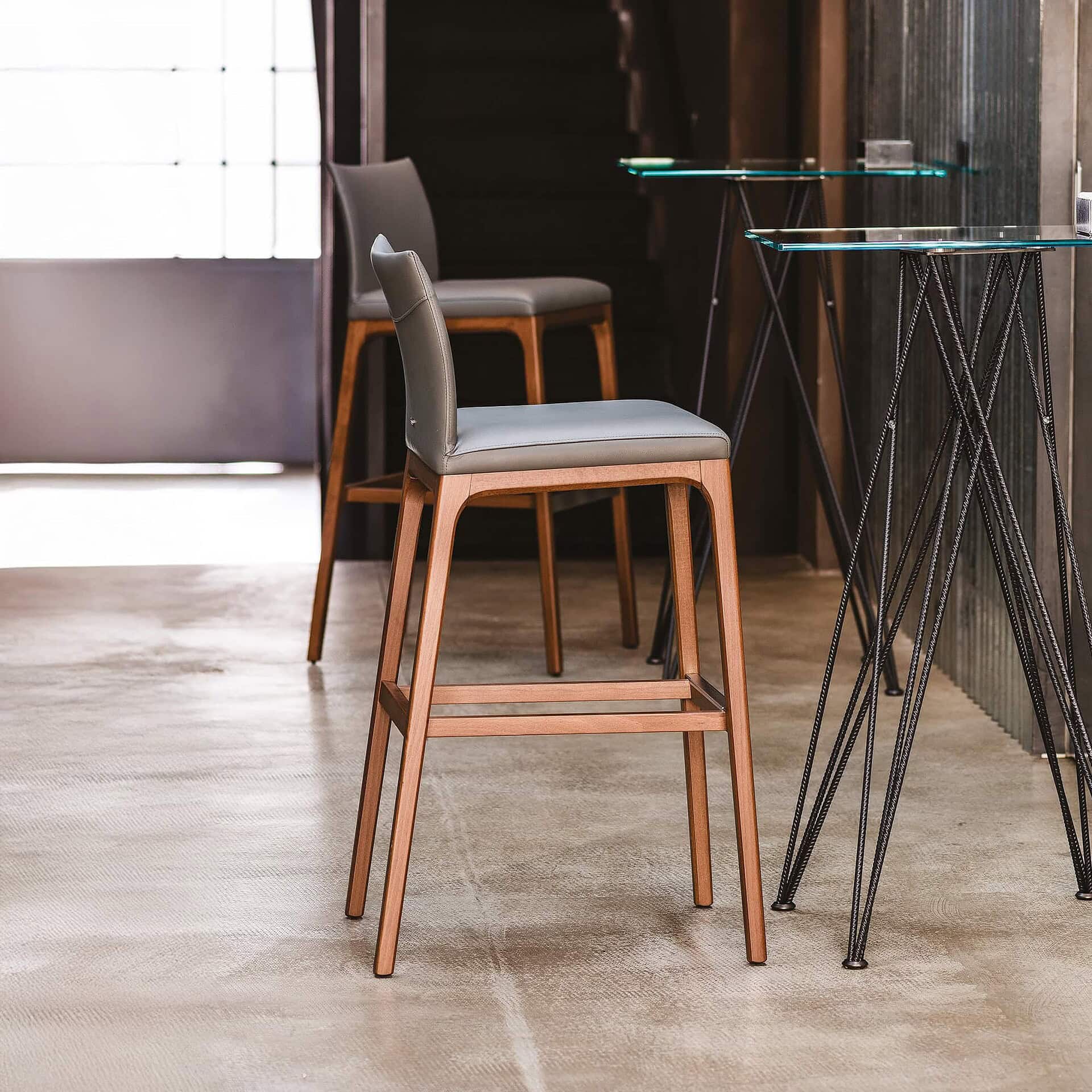Contemporary wooden bar stools with upholstered seats and modern design.