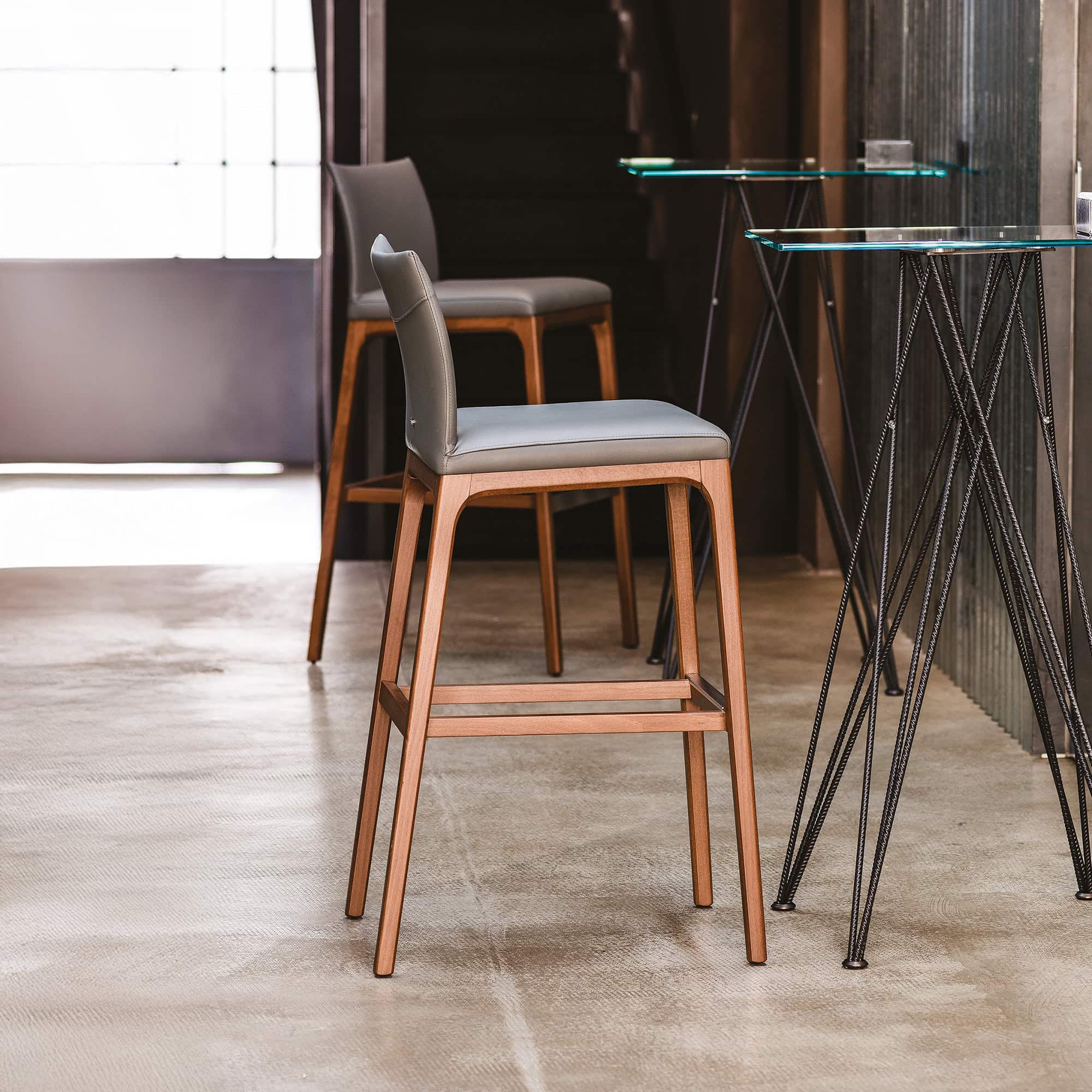 Contemporary wooden bar stools with upholstered seats and modern design.
