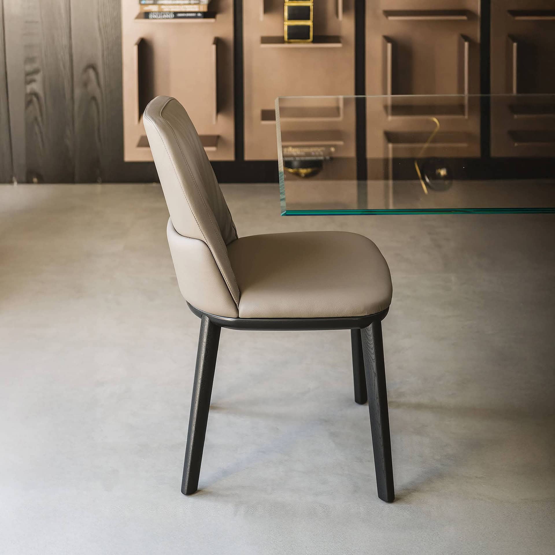 Contemporary beige upholstered dining chair with black wooden legs, modern and stylish furniture design.