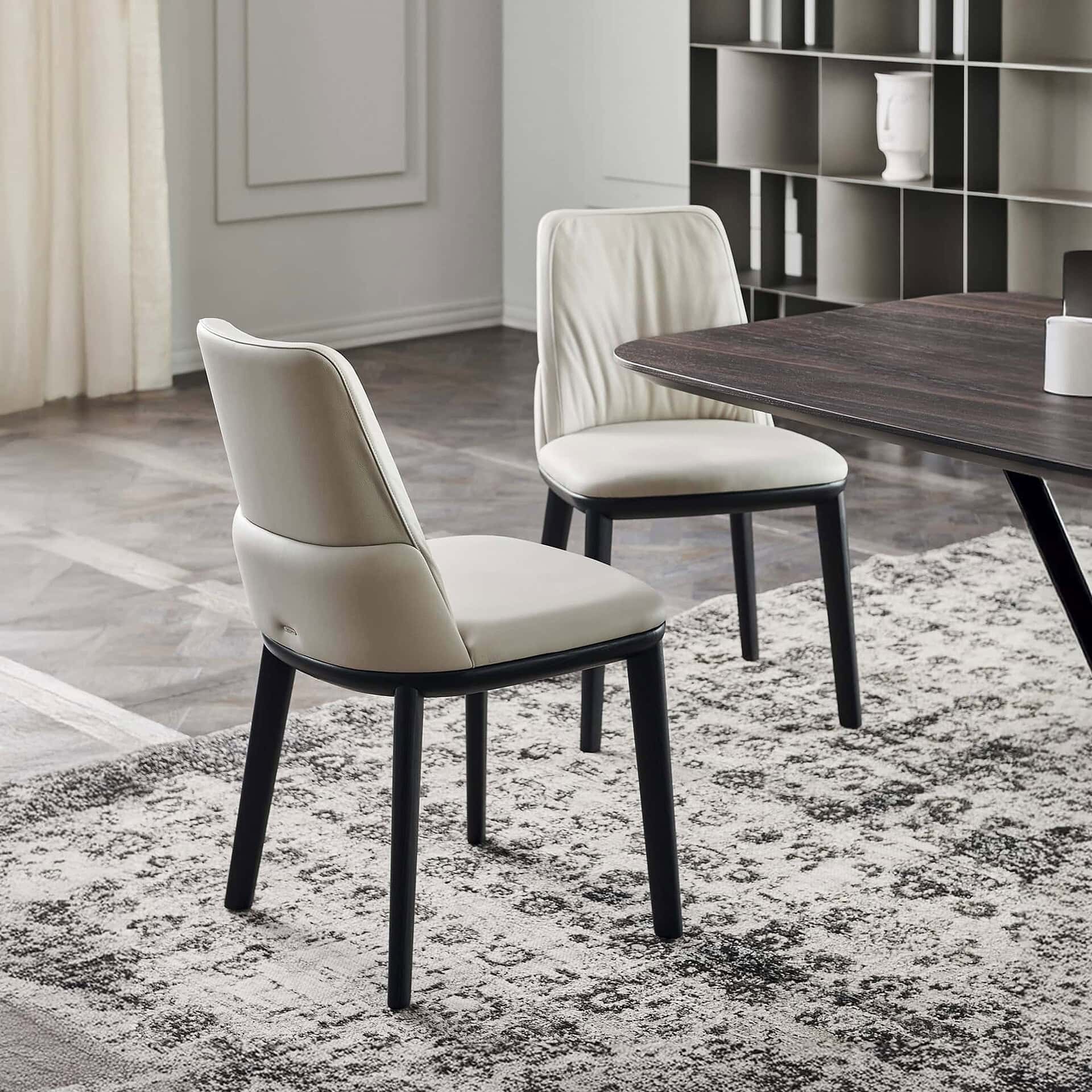 Contemporary dining chairs with upholstered cream seats and black wooden legs in modern interior design.