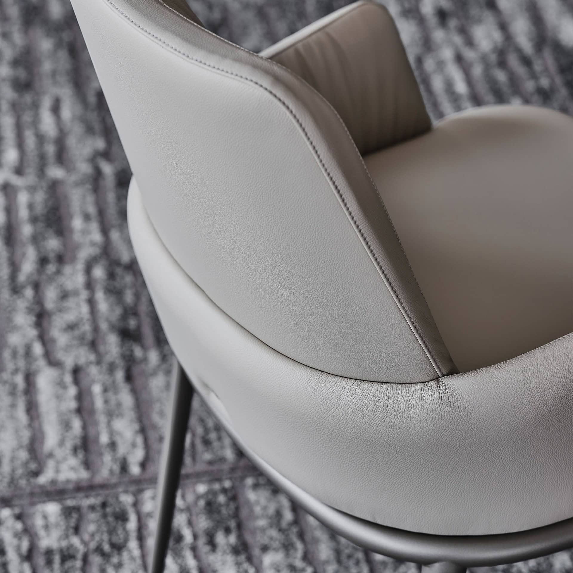 Sleek modern armchair with smooth leather upholstery and minimalist design.