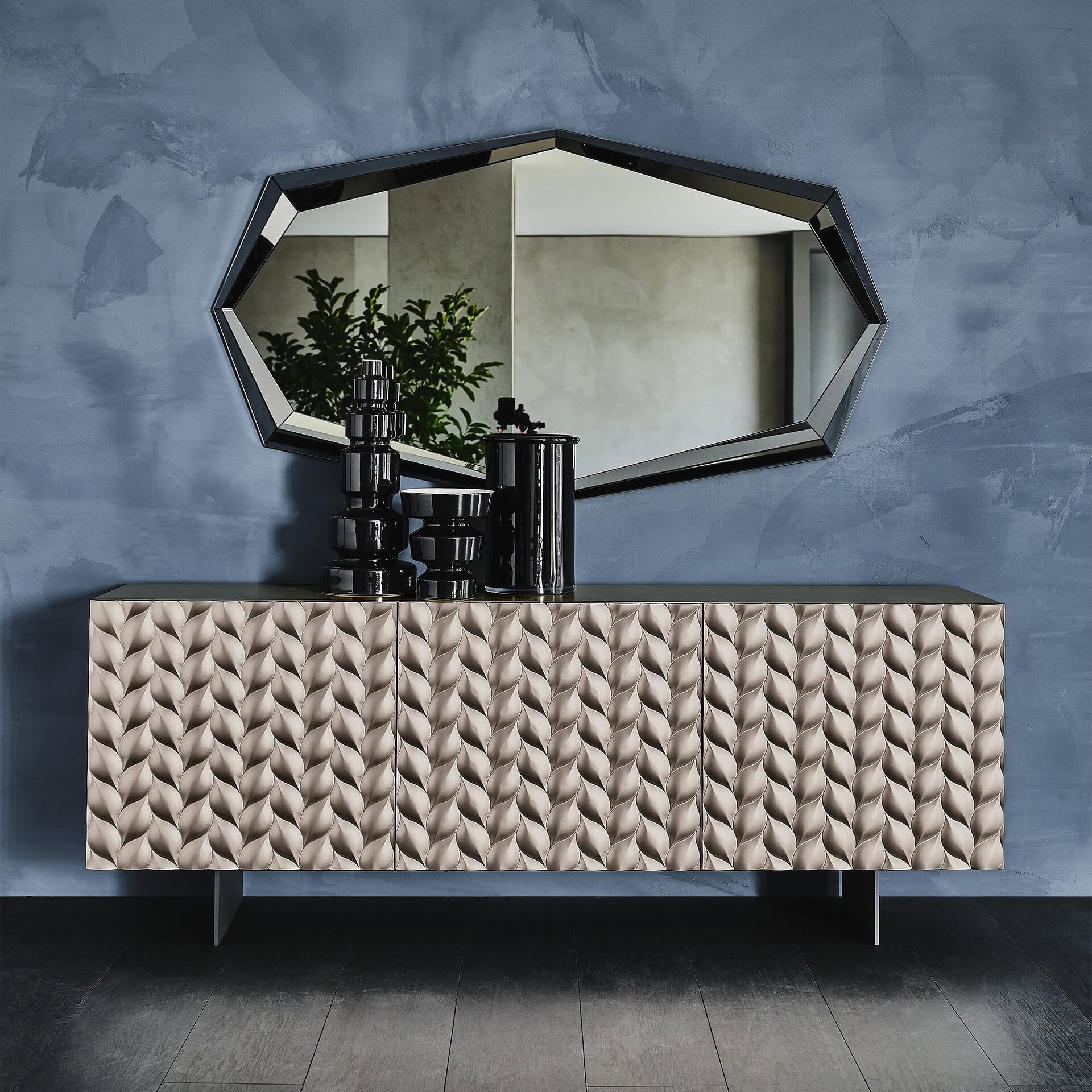 Luxurious modern sideboard with textured geometric design in soft beige, accompanying black decorative accessories and large wall mirror, in contemporary home decor.