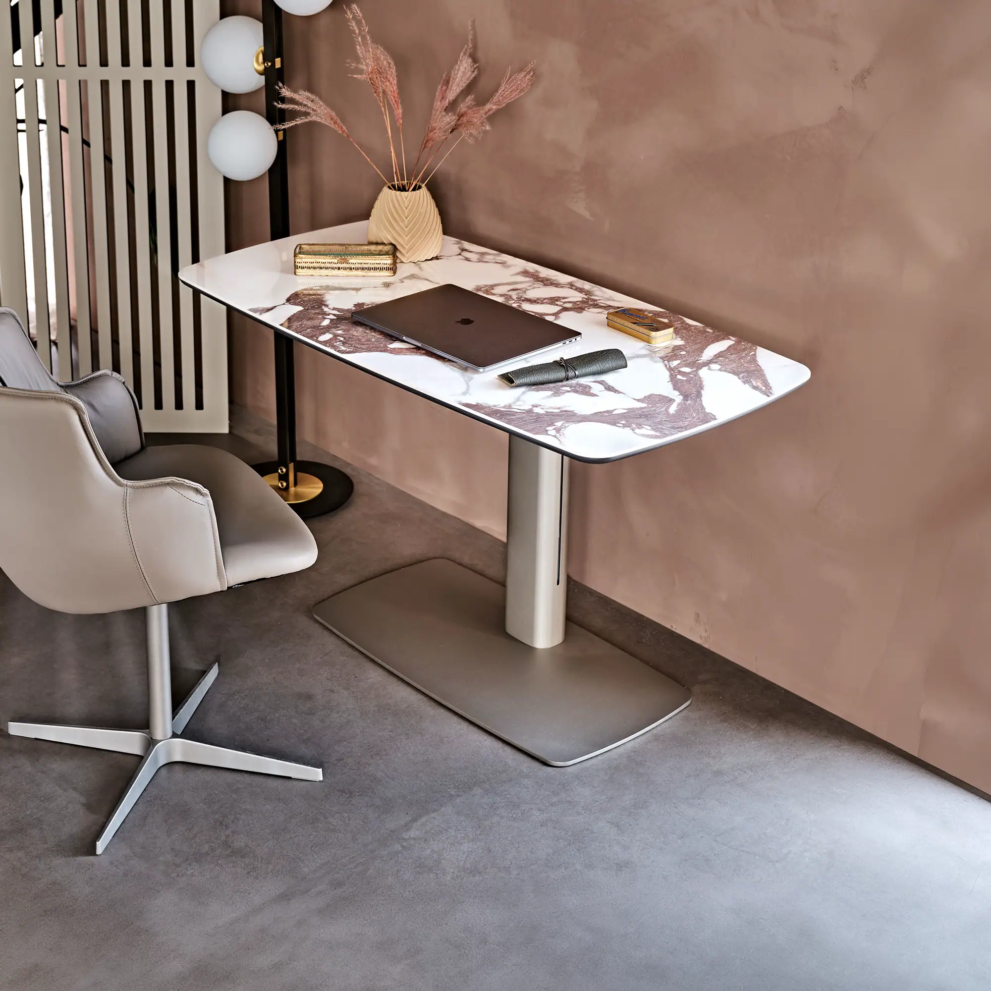 Sklar Furnishings height-adjustable desk with marble top and white base in a modern office.