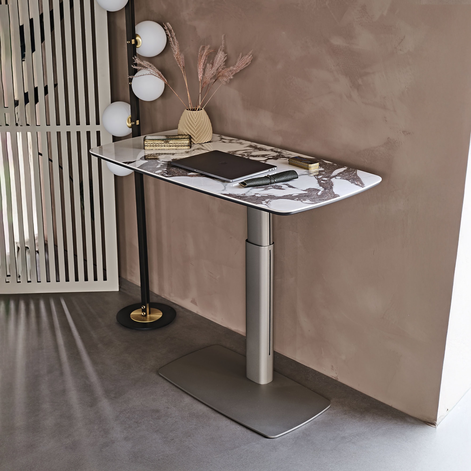 Contemporary adjustable desk with marble top and sleek metallic base, ideal for modern office spaces.