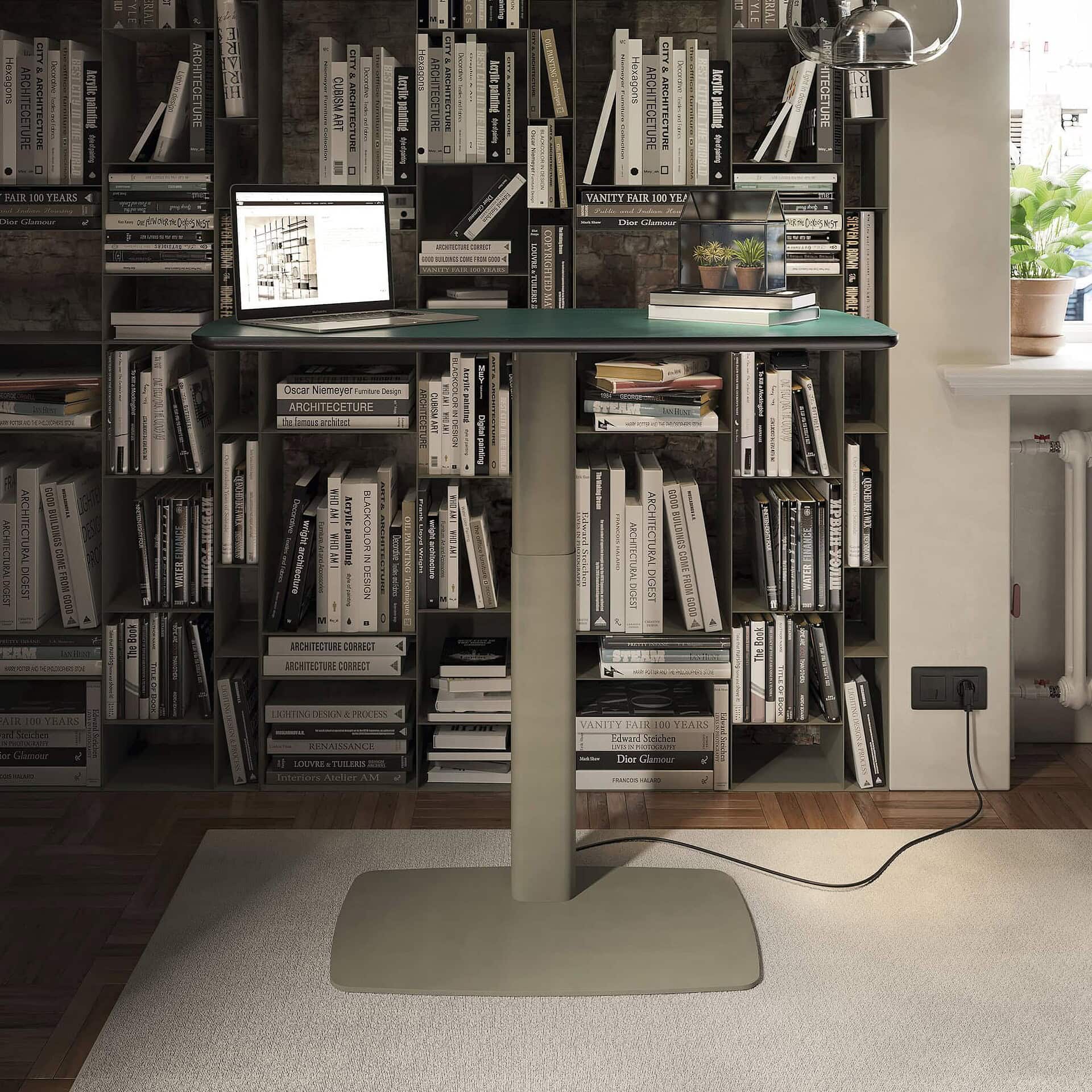 Bookshelf with a computer and desk accessories, modern workspace featuring architectural books and décor.