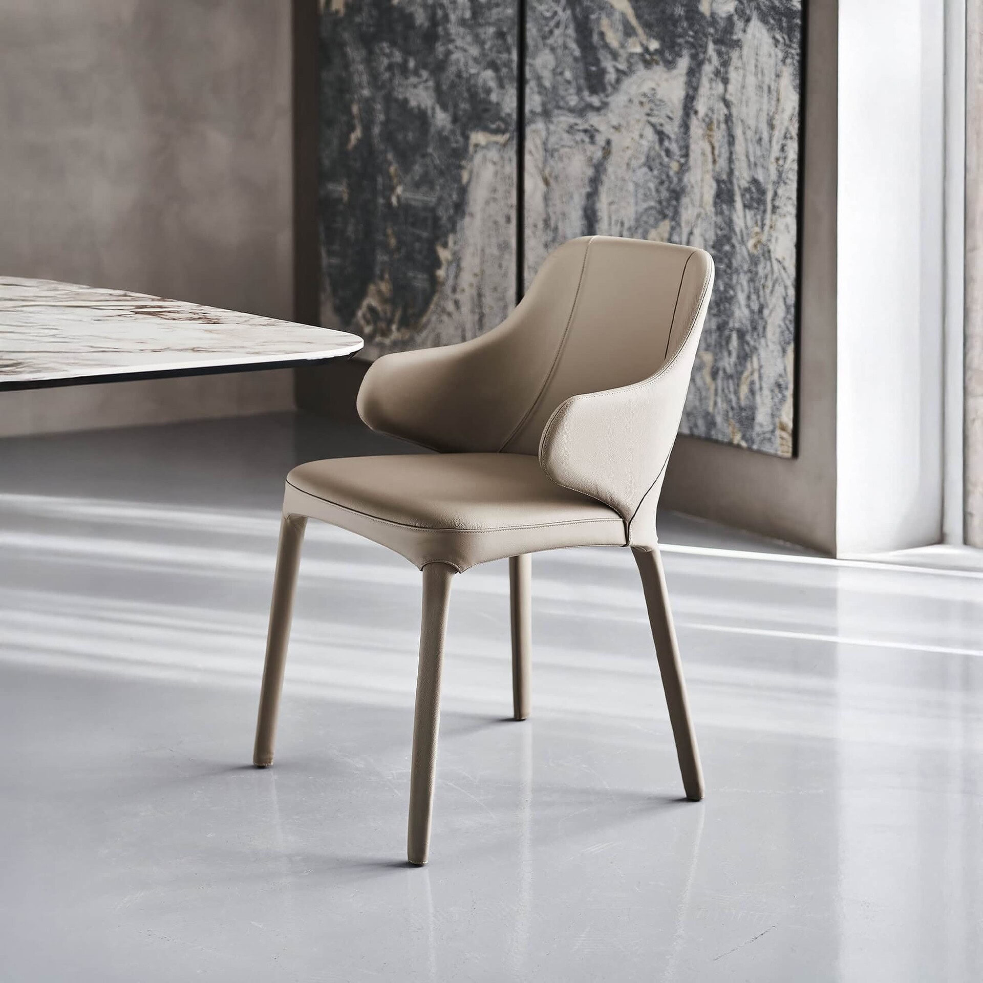 Wanda Dining Chair in soft beige leather with wooden legs, angled front view.