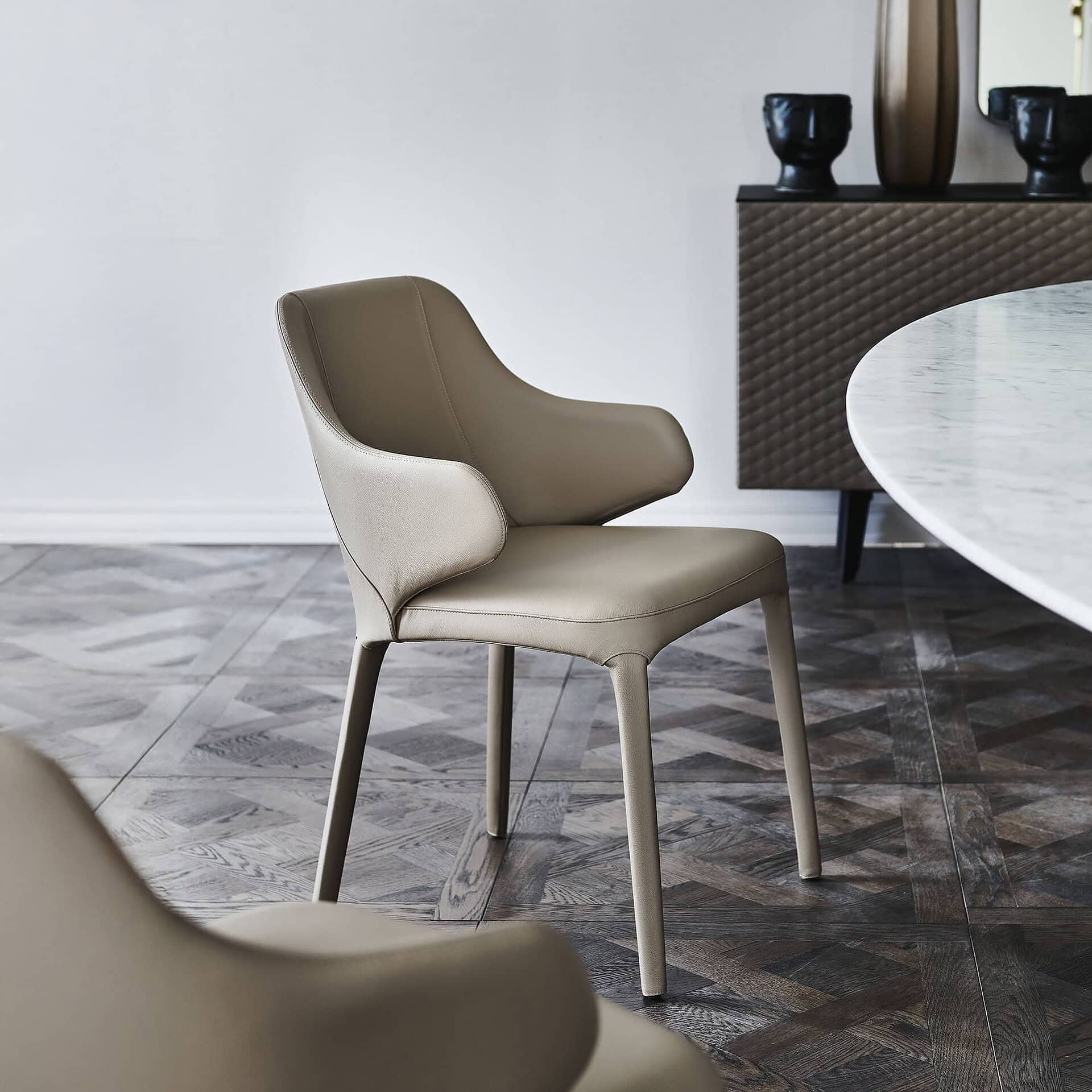 Contemporary beige leather dining chair with sleek design and smooth finish.