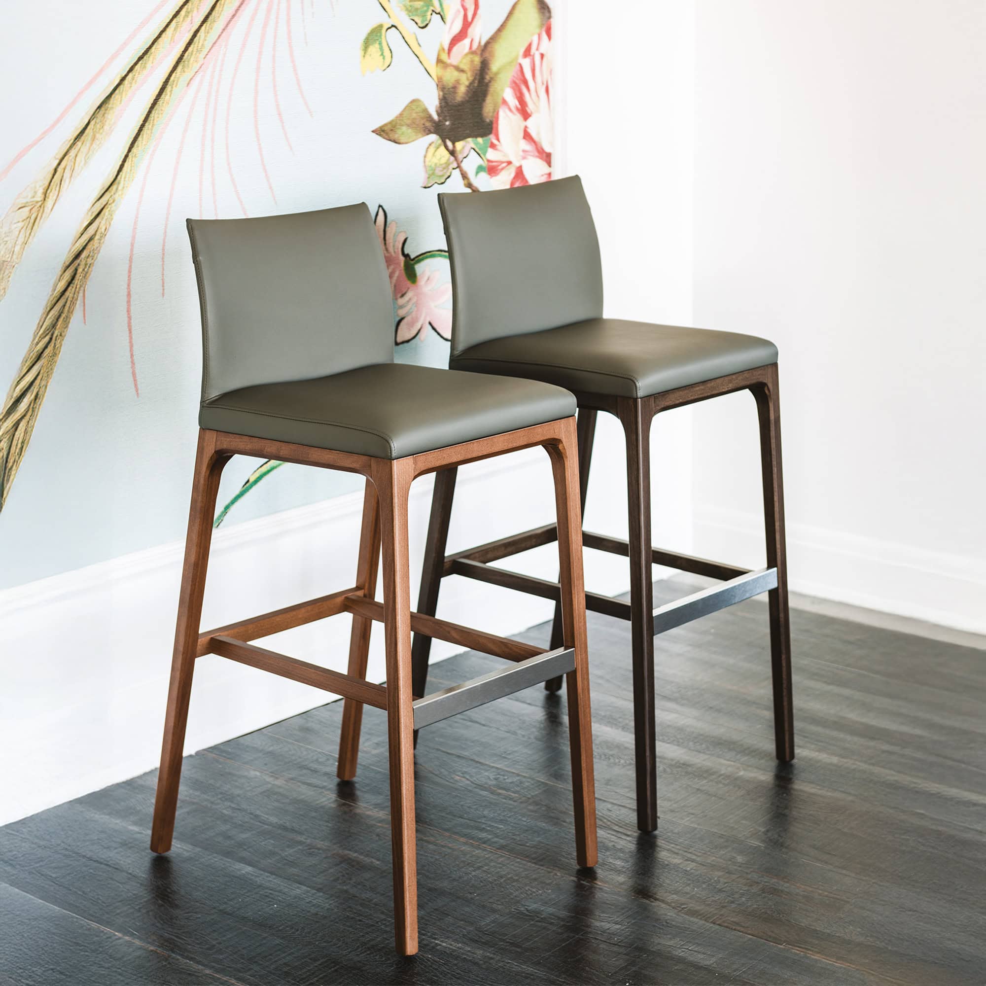Pair of Arcadia Stools with walnut wood frame and dark leather upholstery.
