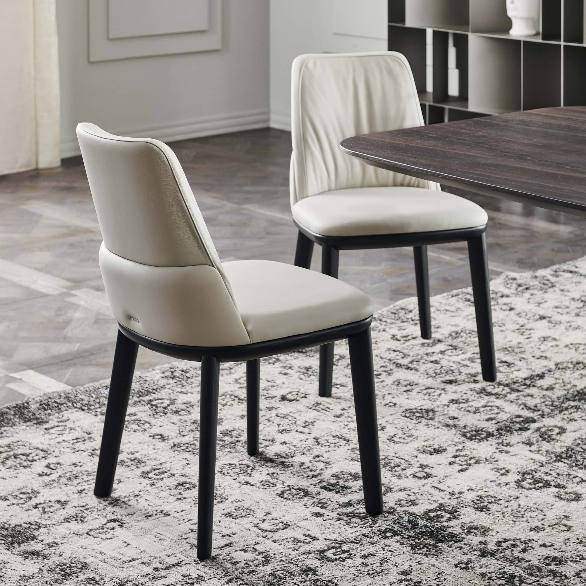 Two Belinda Dining Chairs in neutral tones with black ashwood frames.