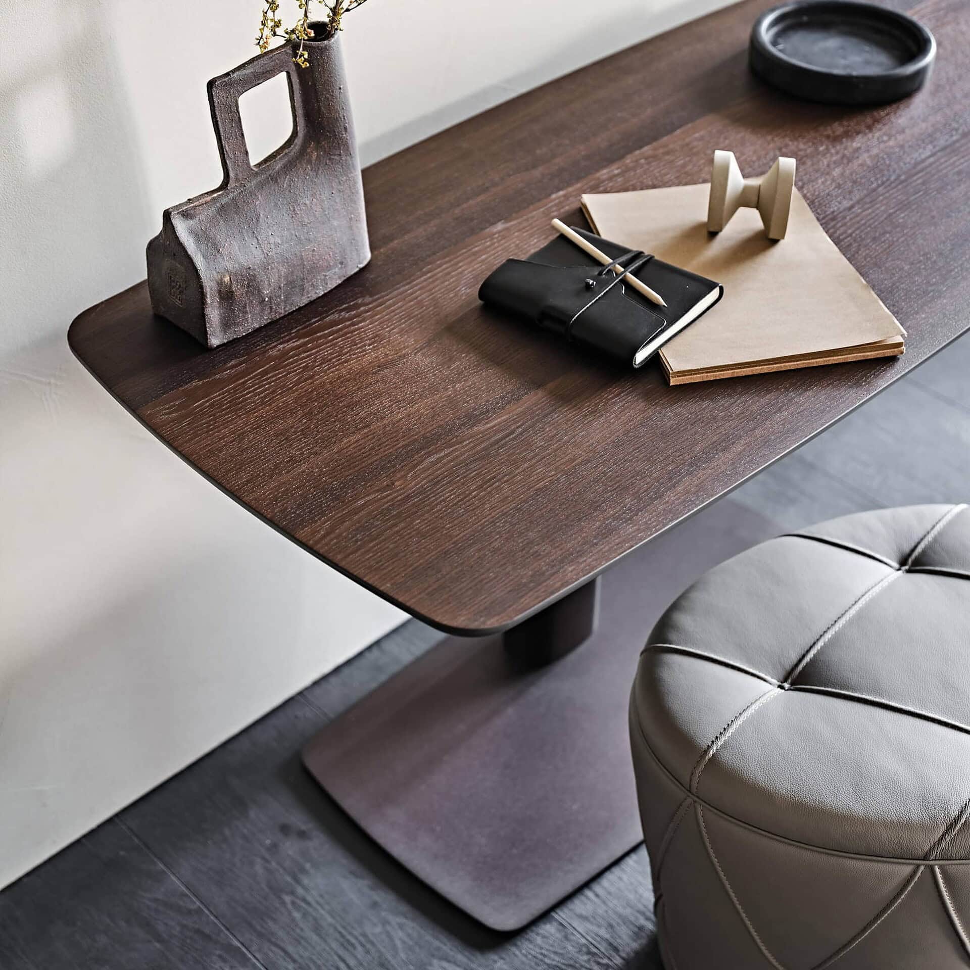 Runner Wood Adjustable Desk in burned oak with bronze embossed metal base, styled workspace with books and accessories