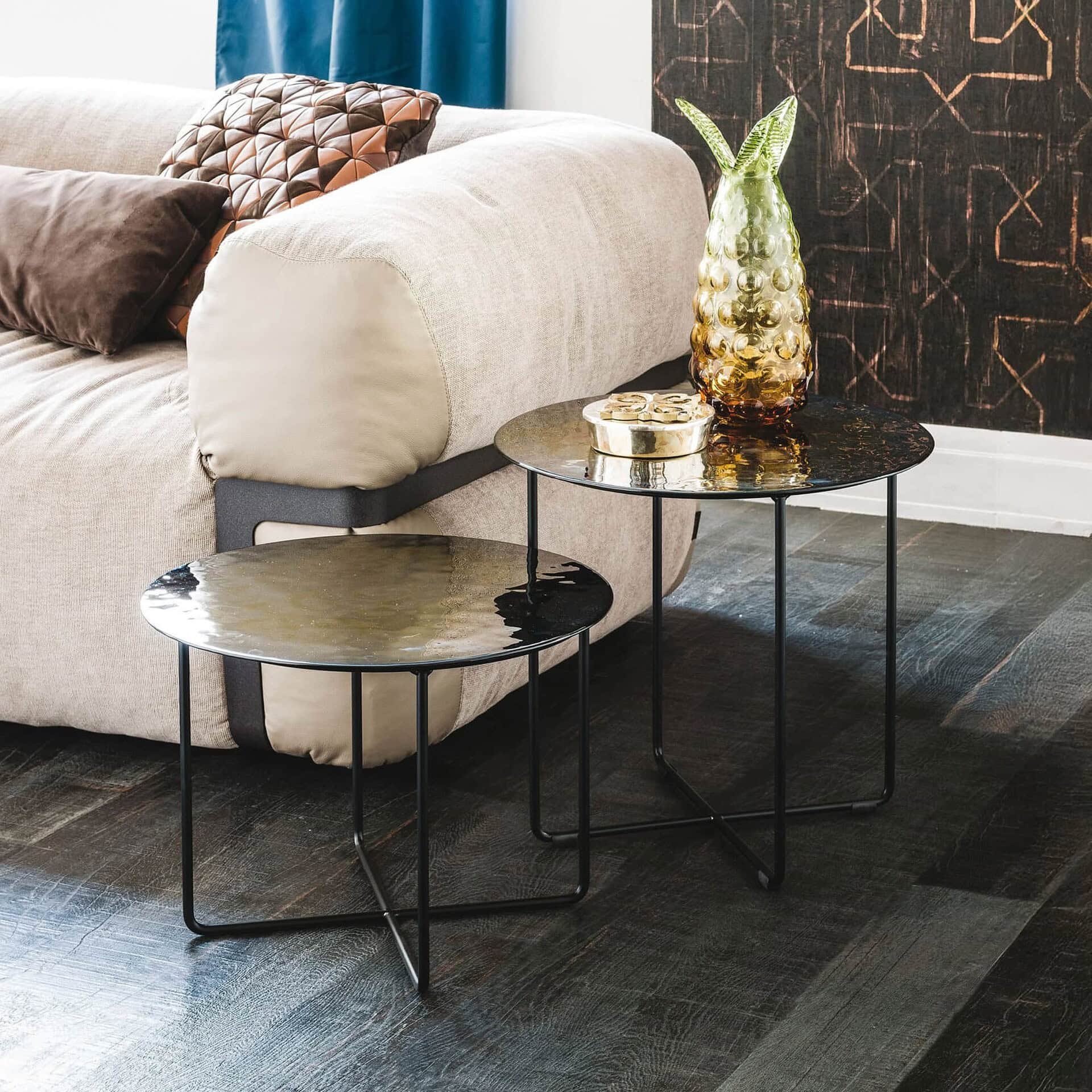 Pair of Vinyl Coffee Tables with round Murano glass tops in a cozy living space with decorative accents.