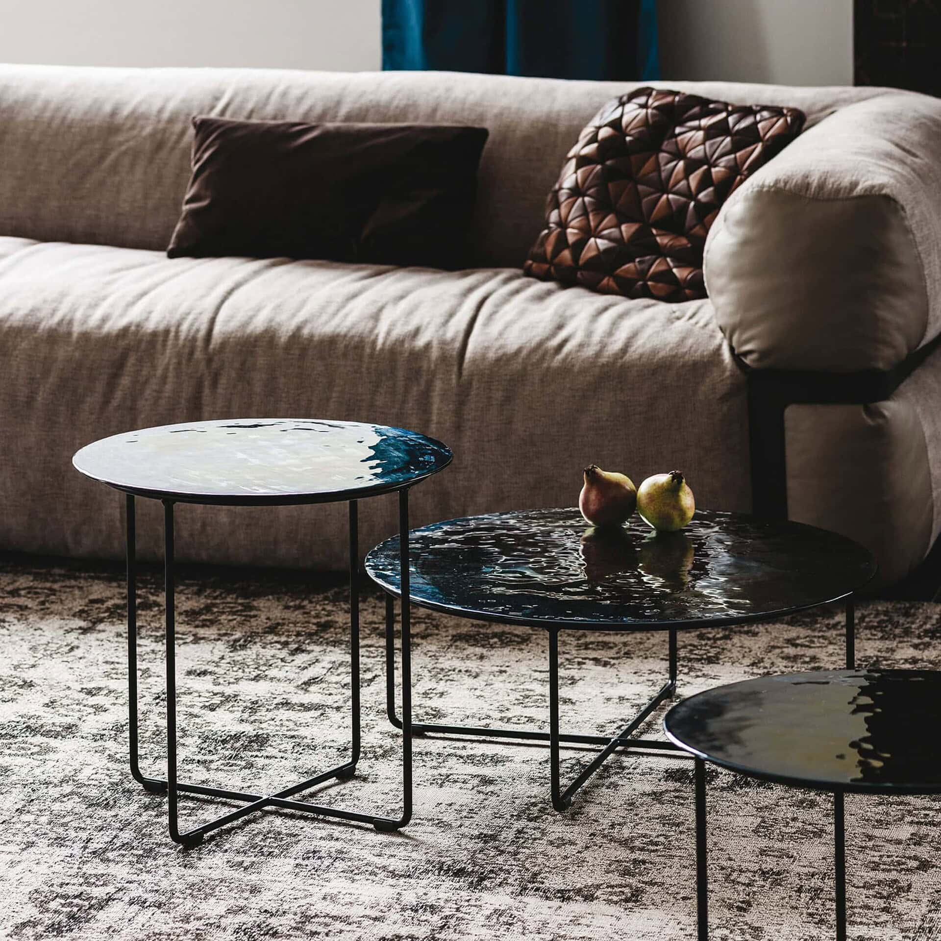 Vinyl Coffee Table with Murano glass top and steel base styled in a modern living room beside a sofa.