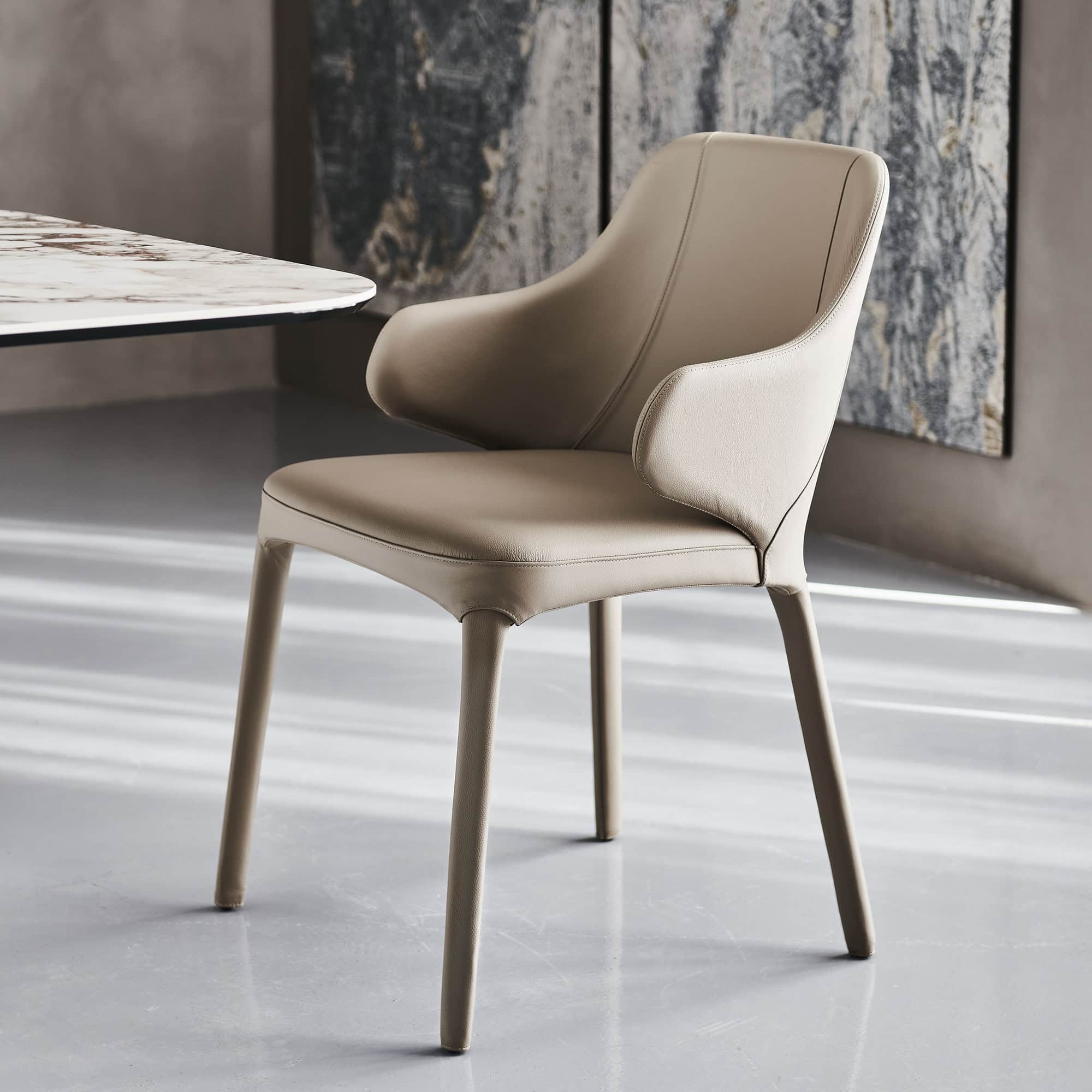 Wanda Dining Chair in soft beige leather with wooden legs, angled front view.