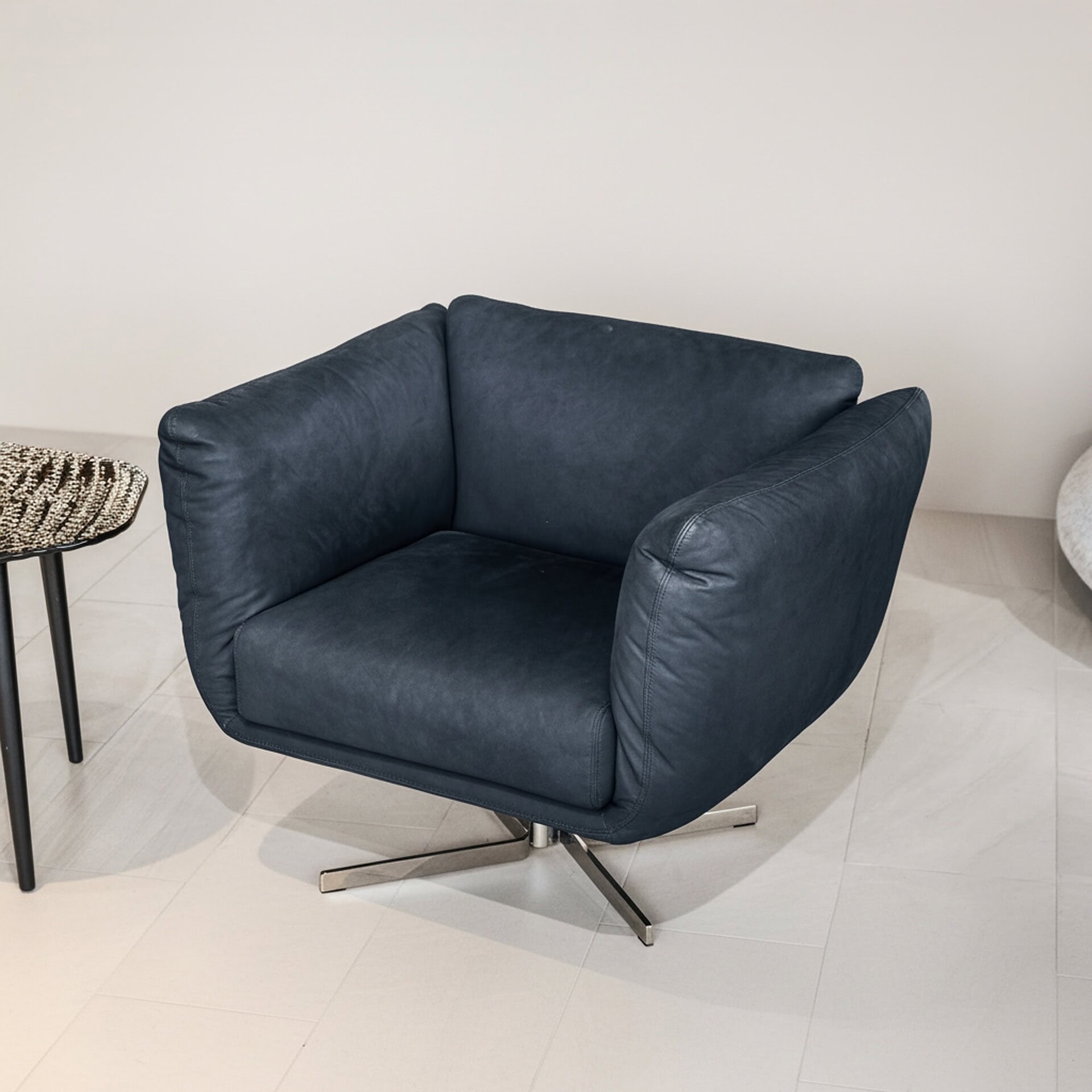Elegant navy blue leather accent chair for modern living room decor.