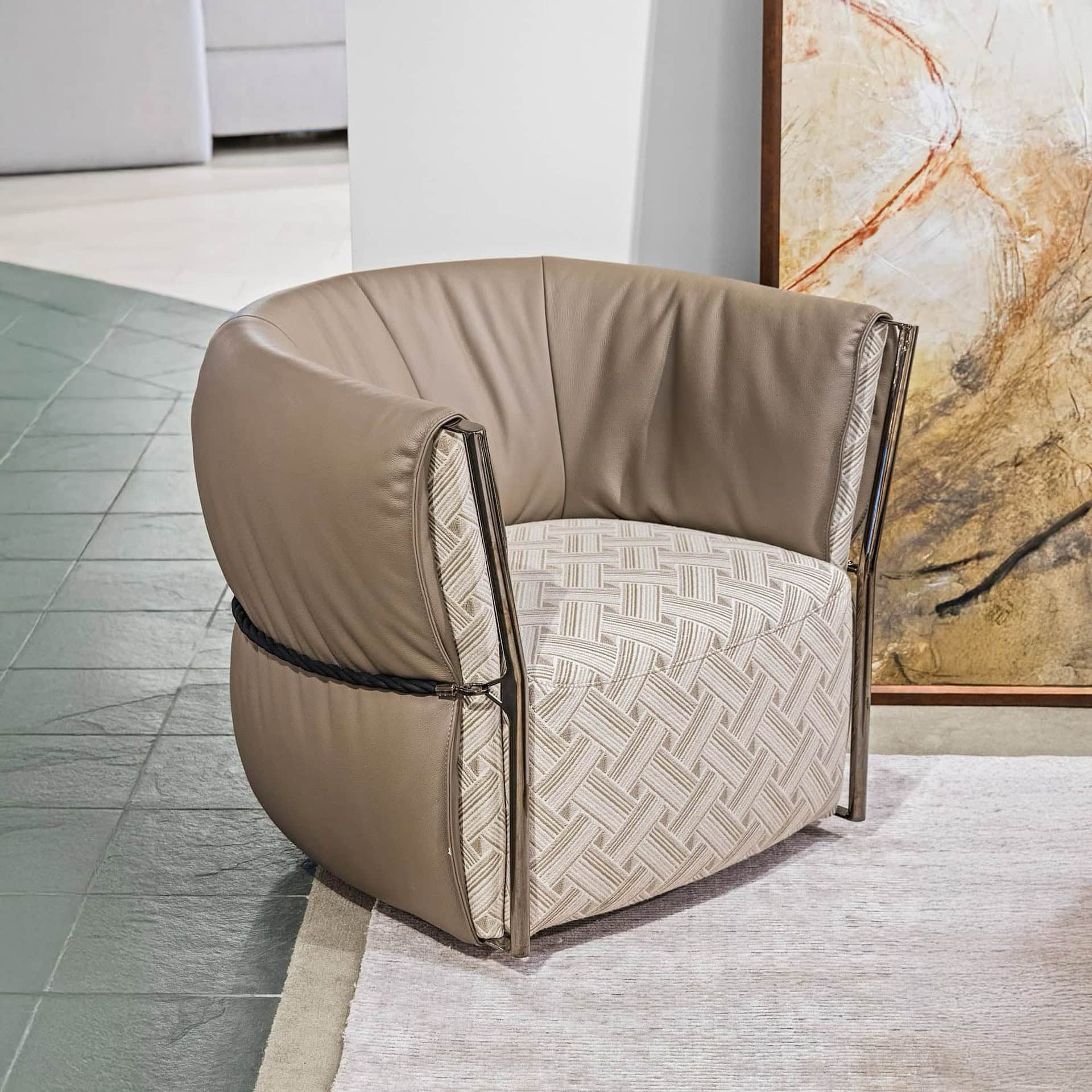 Luxurious beige leather and fabric accent chair with sleek metal details, perfect for modern living spaces.