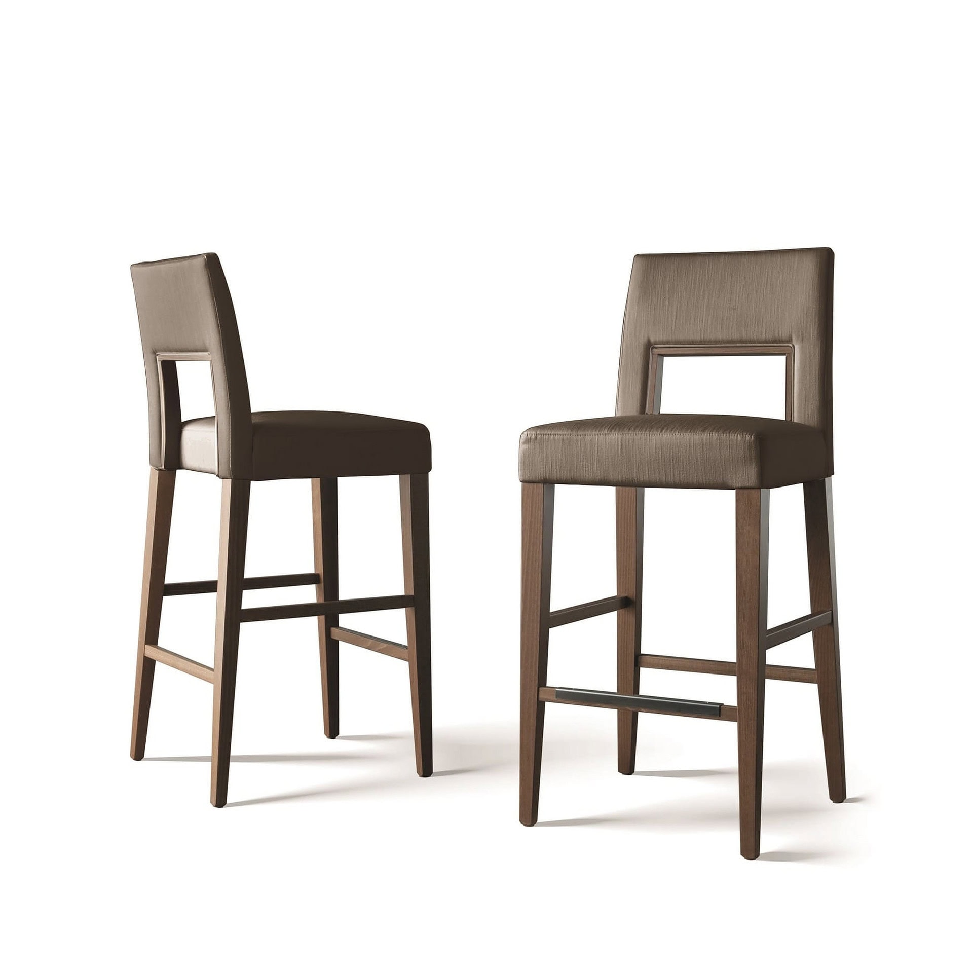 Two modern bar stools with dark wood frames and medium brown upholstered seats and backrests, one with a rectangular cutout in the back, against a white background.