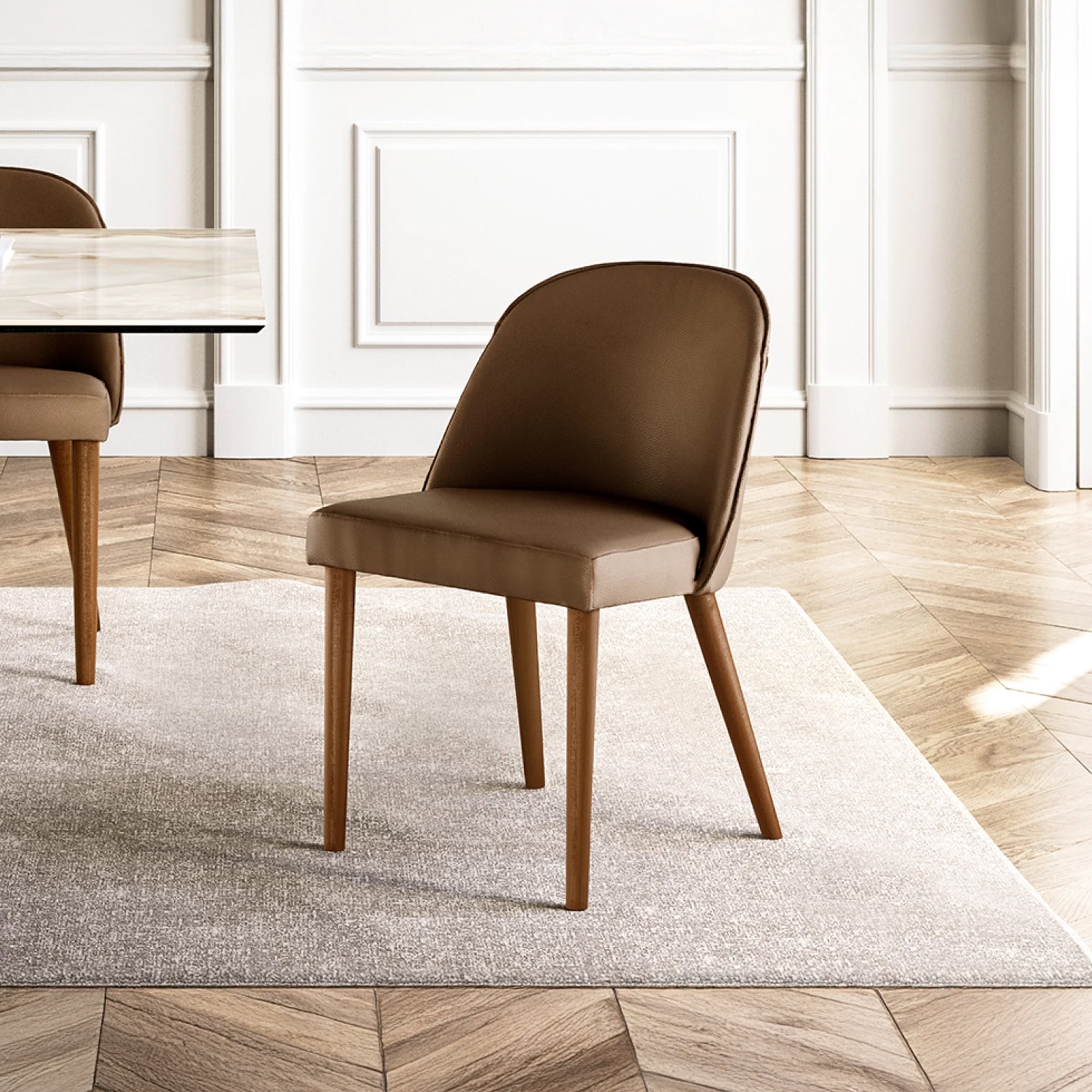 Manta Dining Chair with walnut-stained wooden legs and beige leather upholstery in a bright dining room.