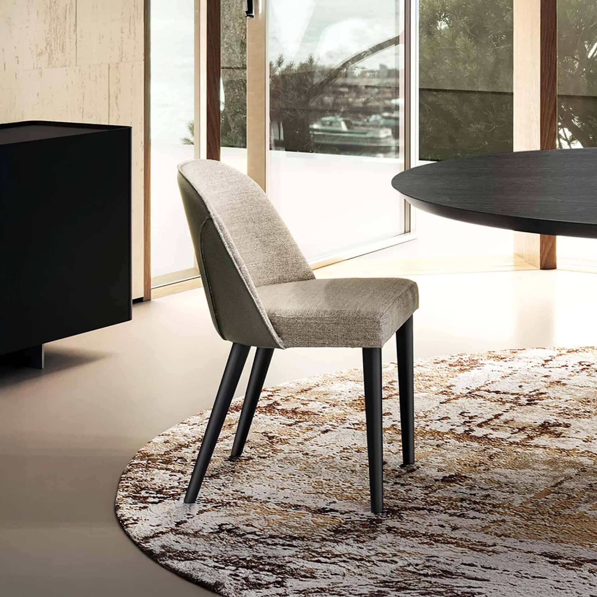 Manta Dining Chair with upholstered seat and back, shown in a modern dining setting.