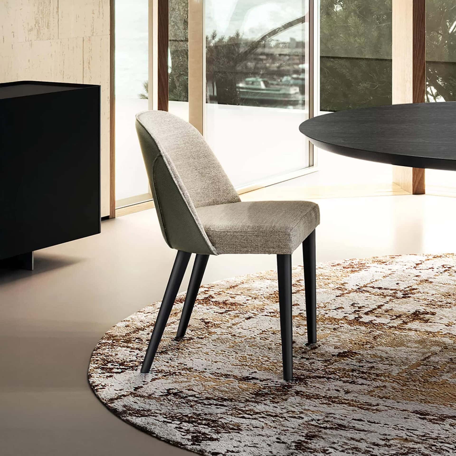 Manta Dining Chair with upholstered seat and back, shown in a modern dining setting.