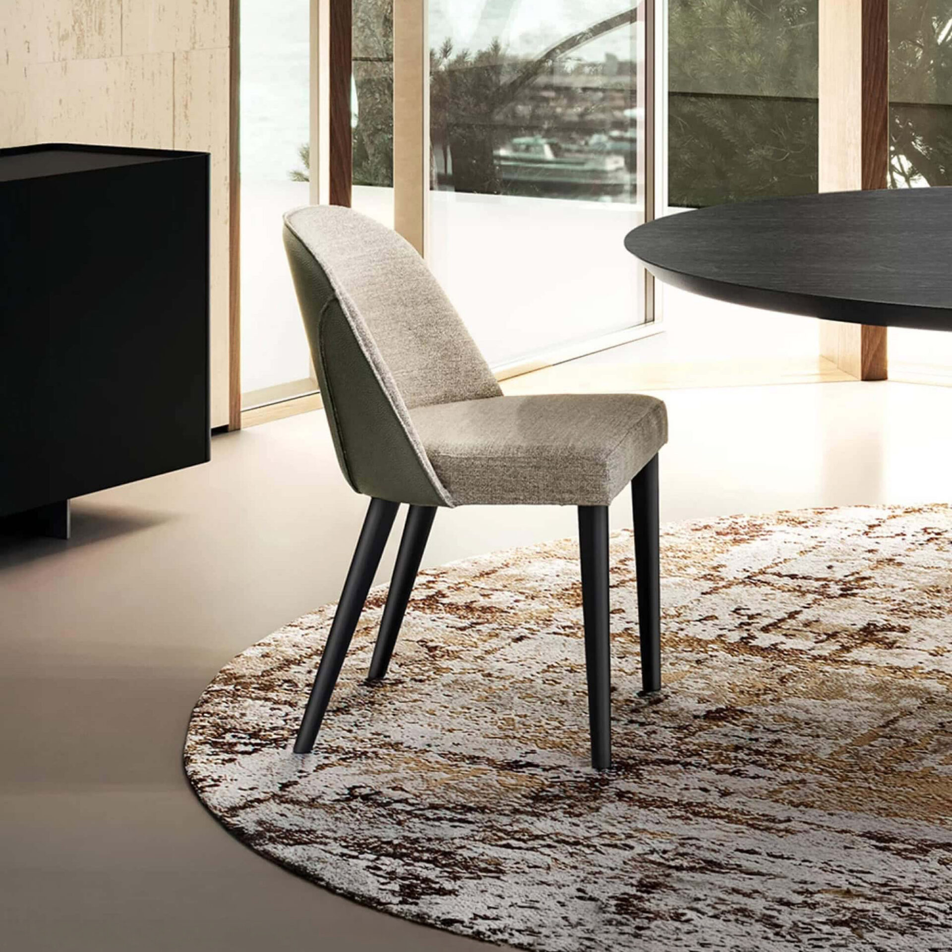 Manta Dining Chair with upholstered seat and back, shown in a modern dining setting.