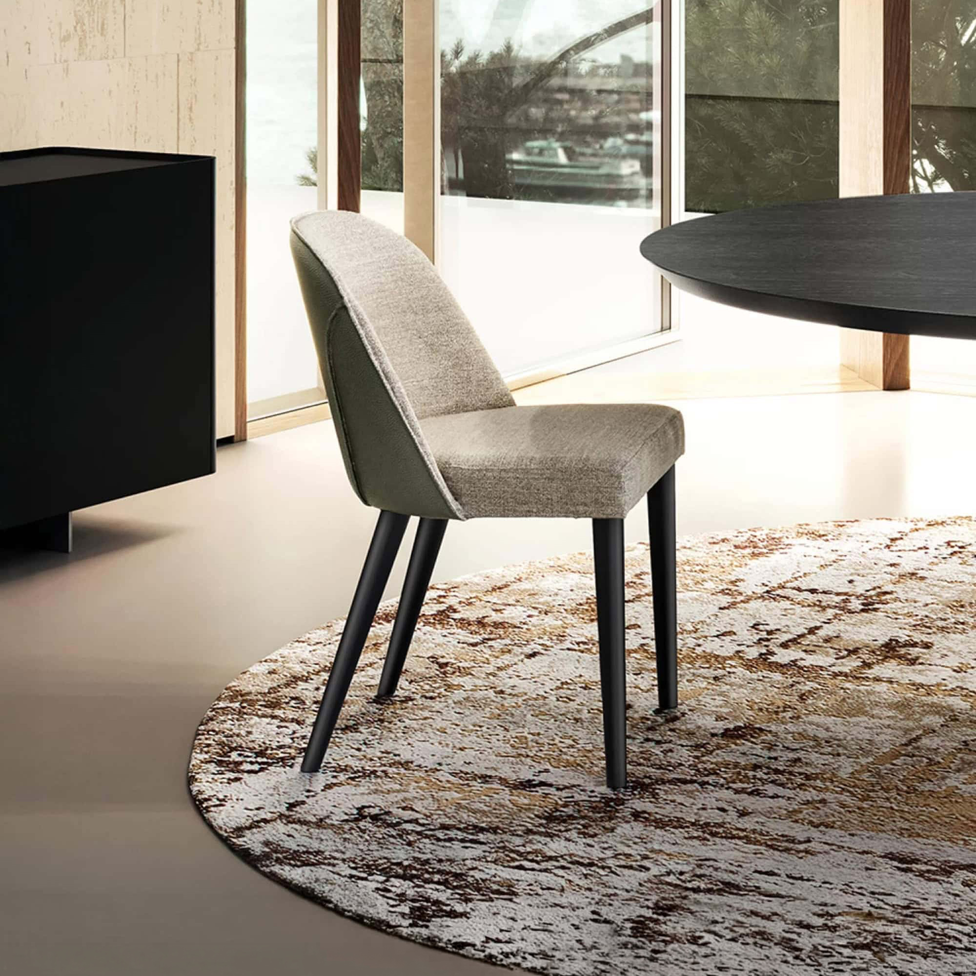 Manta Dining Chair with upholstered seat and back, shown in a modern dining setting.