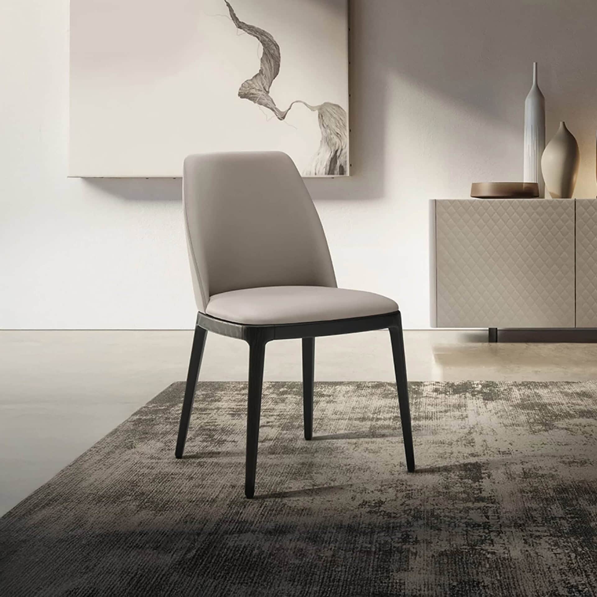 Sleek modern dining chair with cushioned seat and back, black wooden legs, in contemporary interior setting.