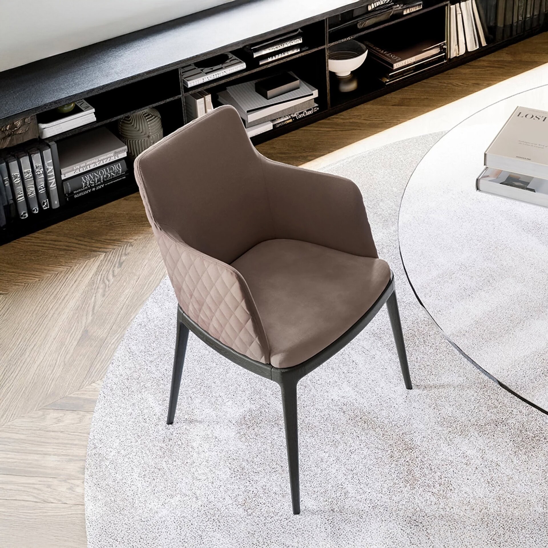 Contemporary upholstered accent chair with sleek black legs in modern living room setting.