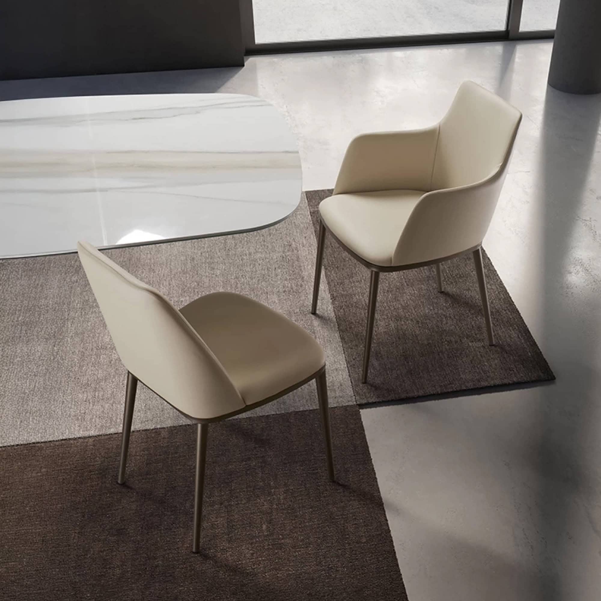 Contemporary dining chairs in beige with sleek metal legs on a textured rug.