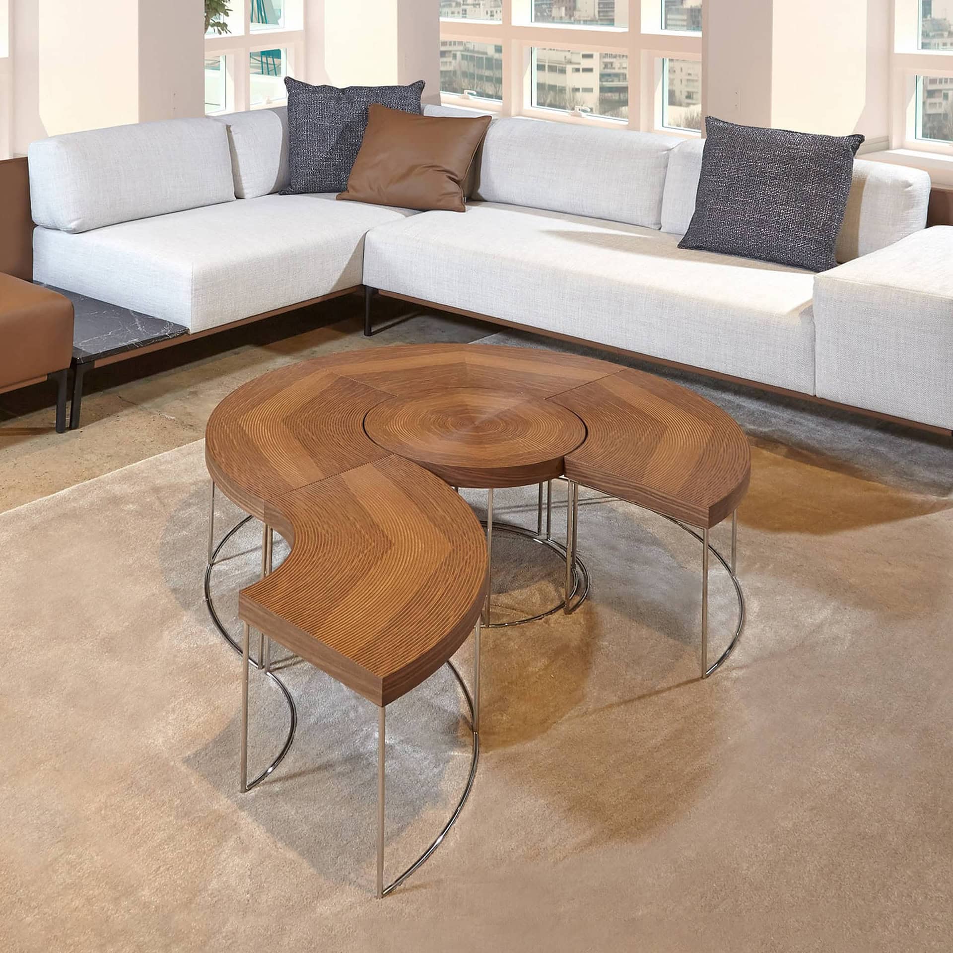 Sini Modular Coffee Table set in walnut with modular curved design and metal legs, styled in a contemporary living room.