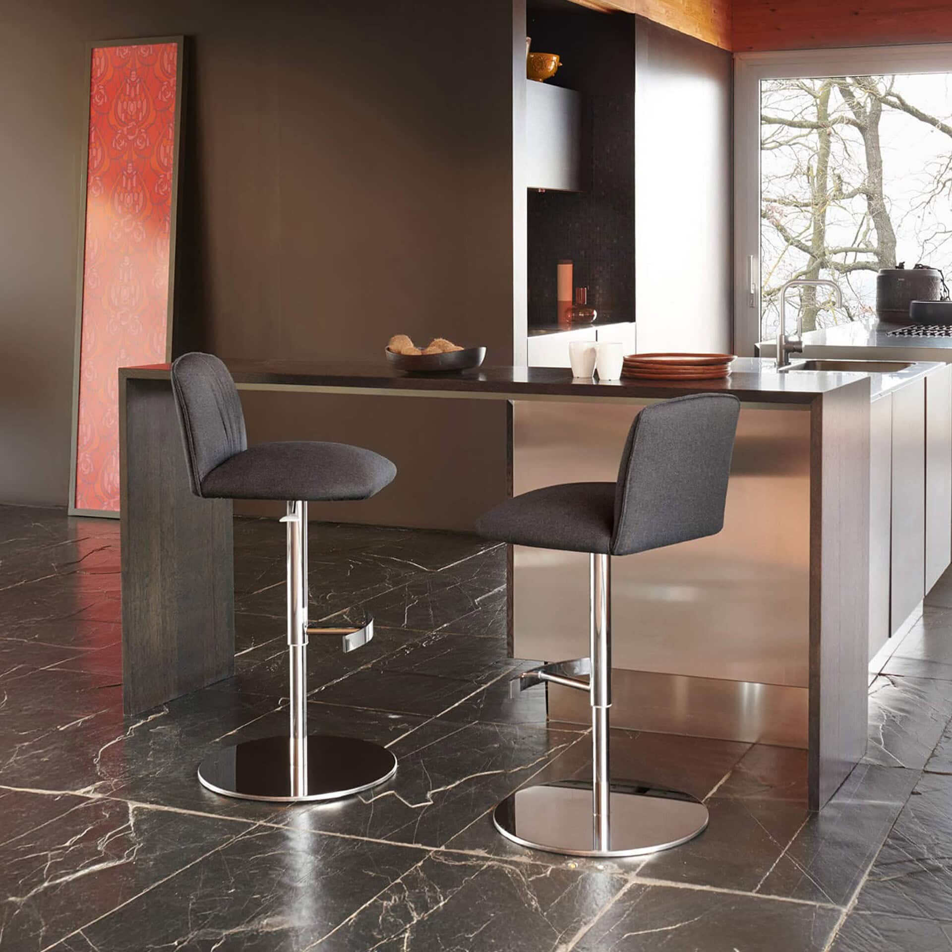 Blossom stools with sleek metal bases and upholstered seats styled at a modern kitchen counter.