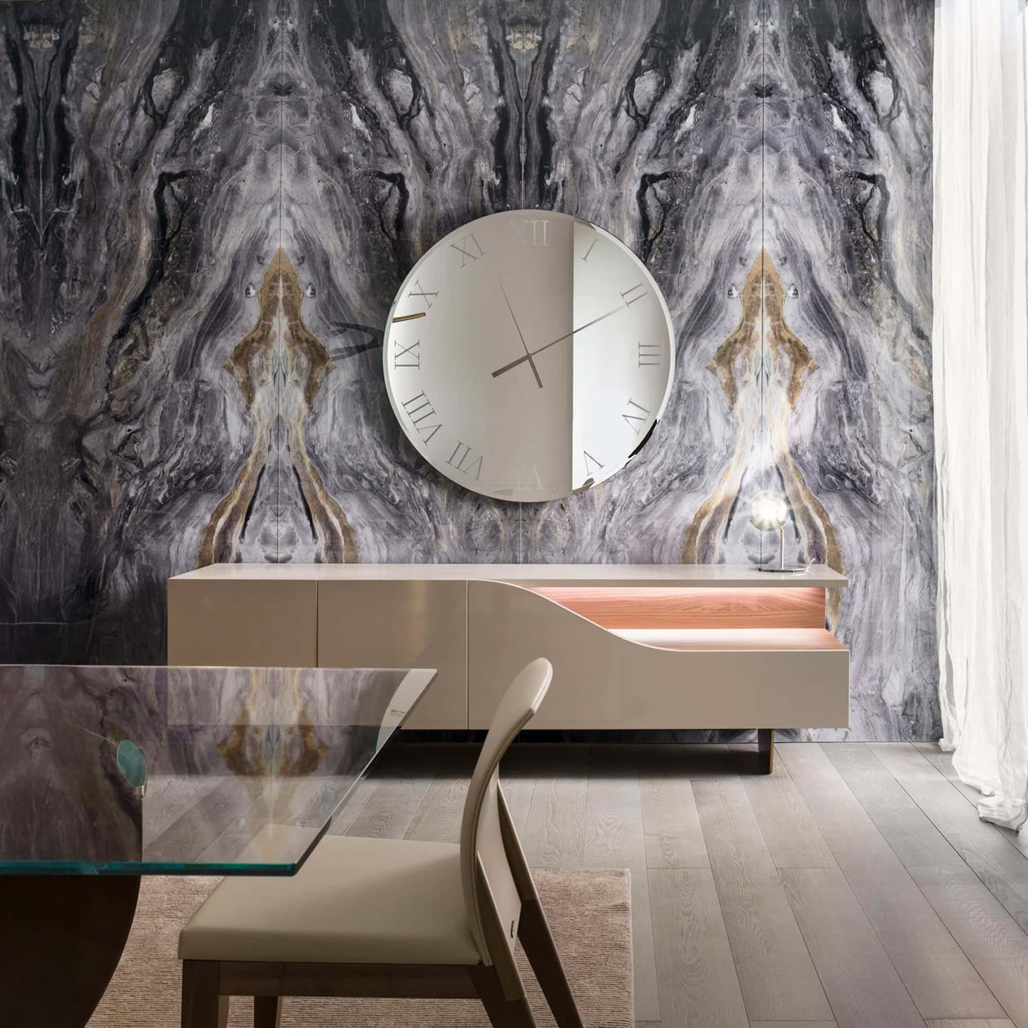 Dining room setting featuring the Segno Buffet with a round mirror above and marble wall backdrop.