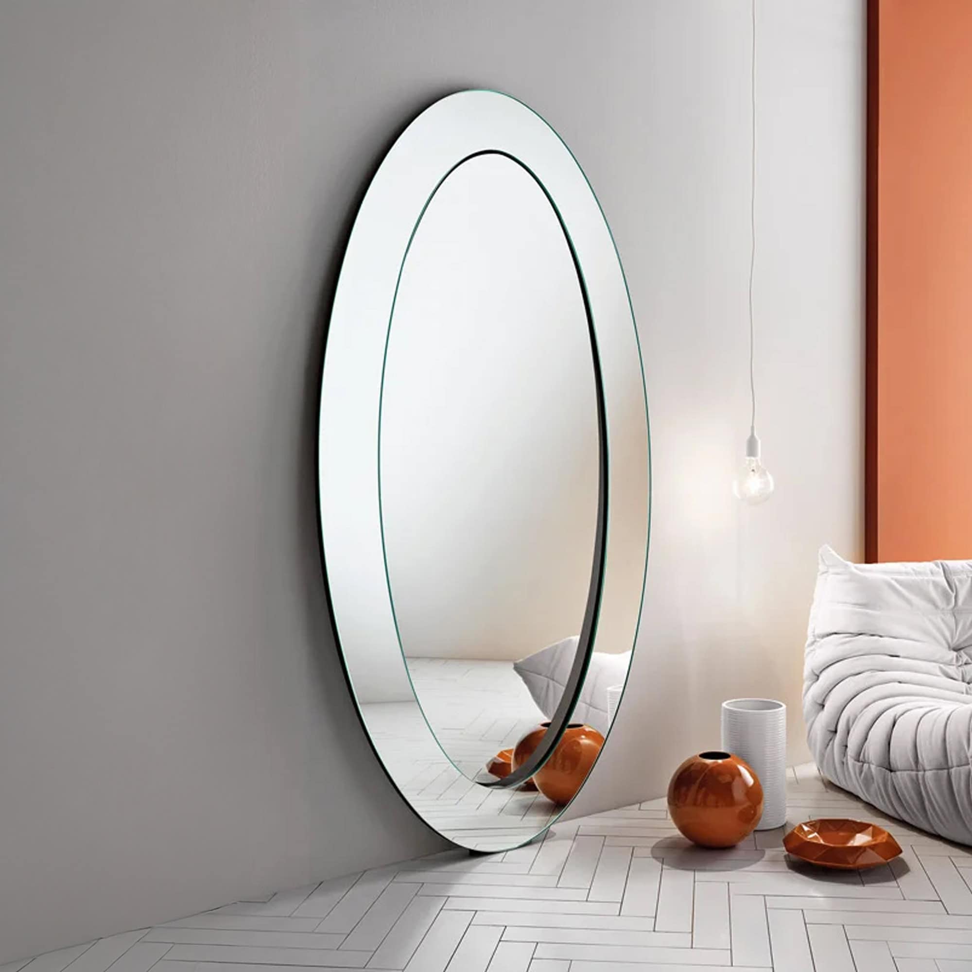Tonelli Design Gerundio oval mirror with beveled edge detail in a bedroom.