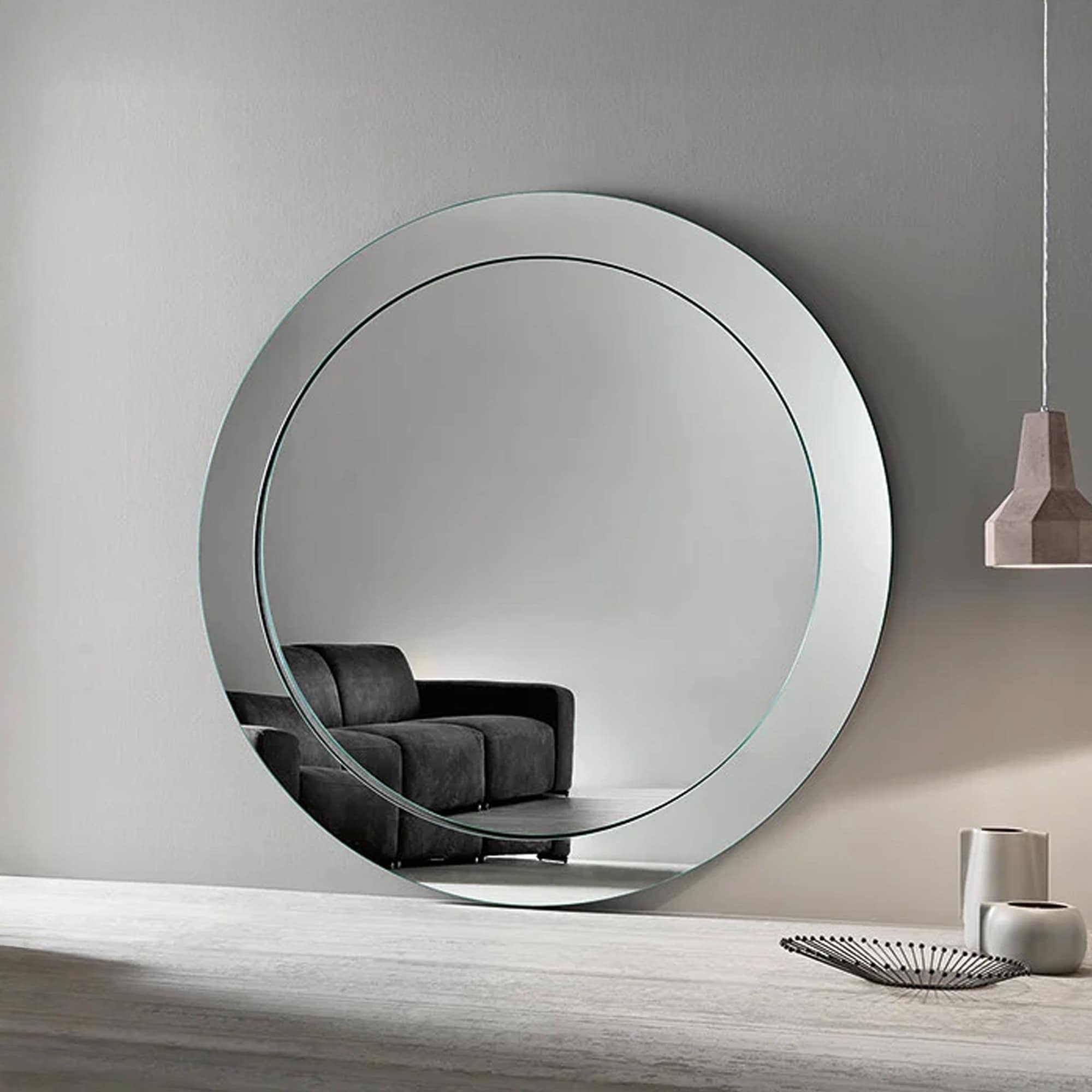 Tonelli Design Gerundio round mirror with inclined profile styled in a modern neutral living space.