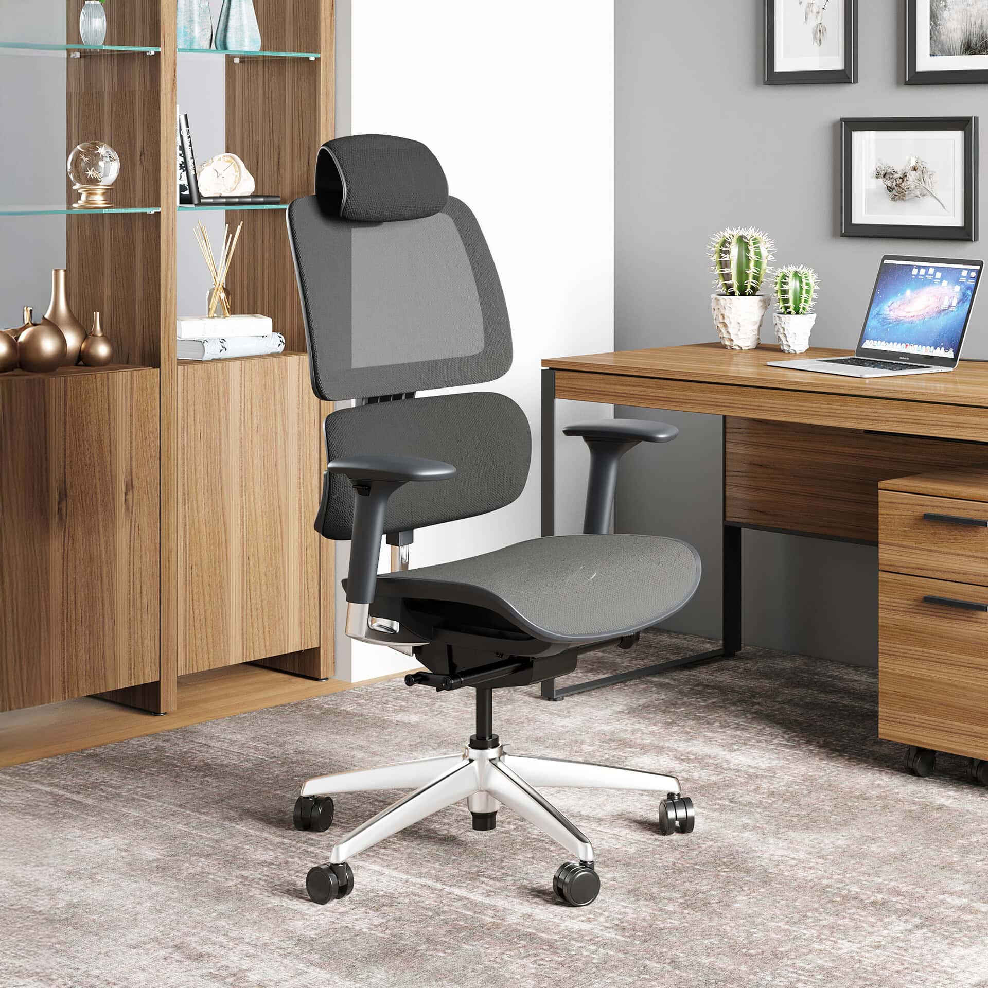 A dark gray ergonomic office chair with a white base sits in a modern home office, featuring a wooden desk with a laptop and cacti, and a wooden bookshelf.