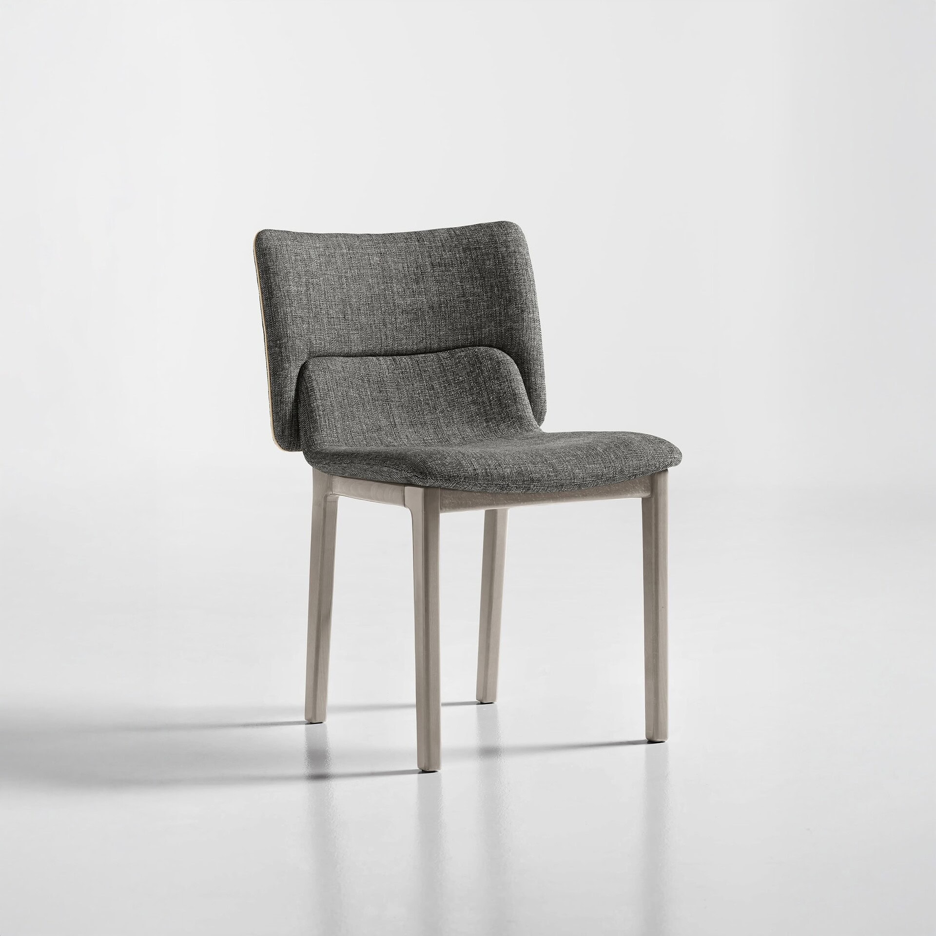 Front angled view of the Nora Dining Chair in light fabric with wooden legs.